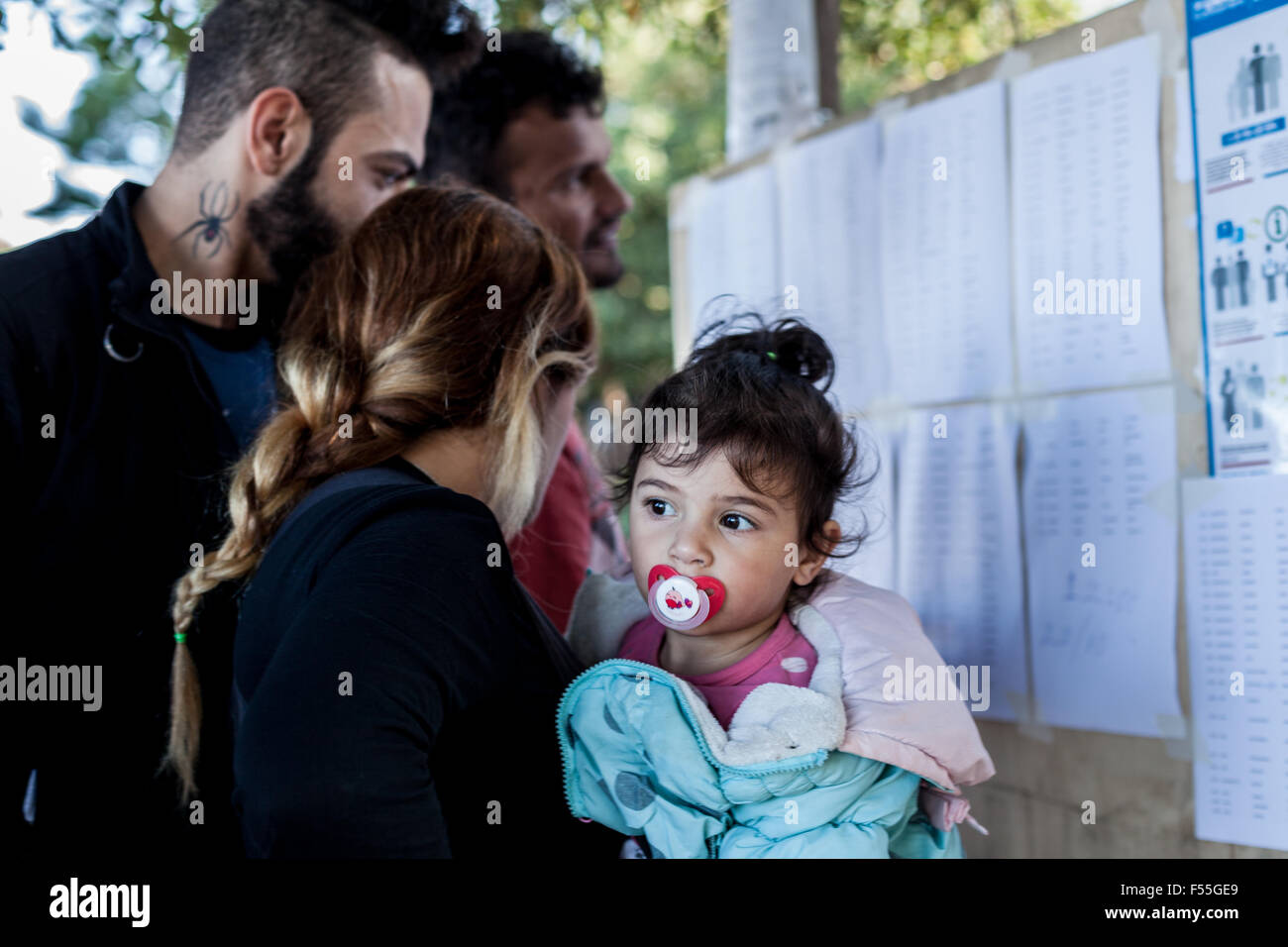 I migranti dalla Siria controllare il loro numero in una linea per essere registrati su Kos stazione di polizia il 26 di ottobre 2015. Ogni immigrato w Foto Stock