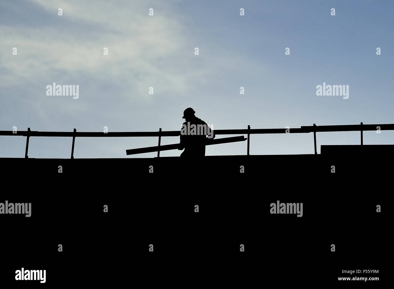 Operaio edile silhouette su una costruzione con cielo blu su sfondo Foto Stock