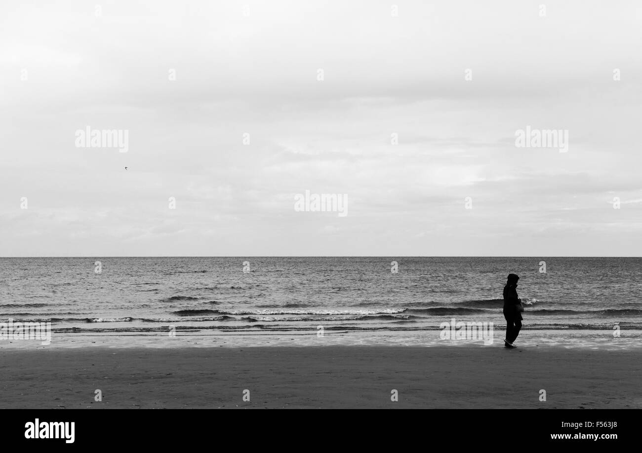 Figura solitaria sulla spiaggia Brancaster. Foto Stock