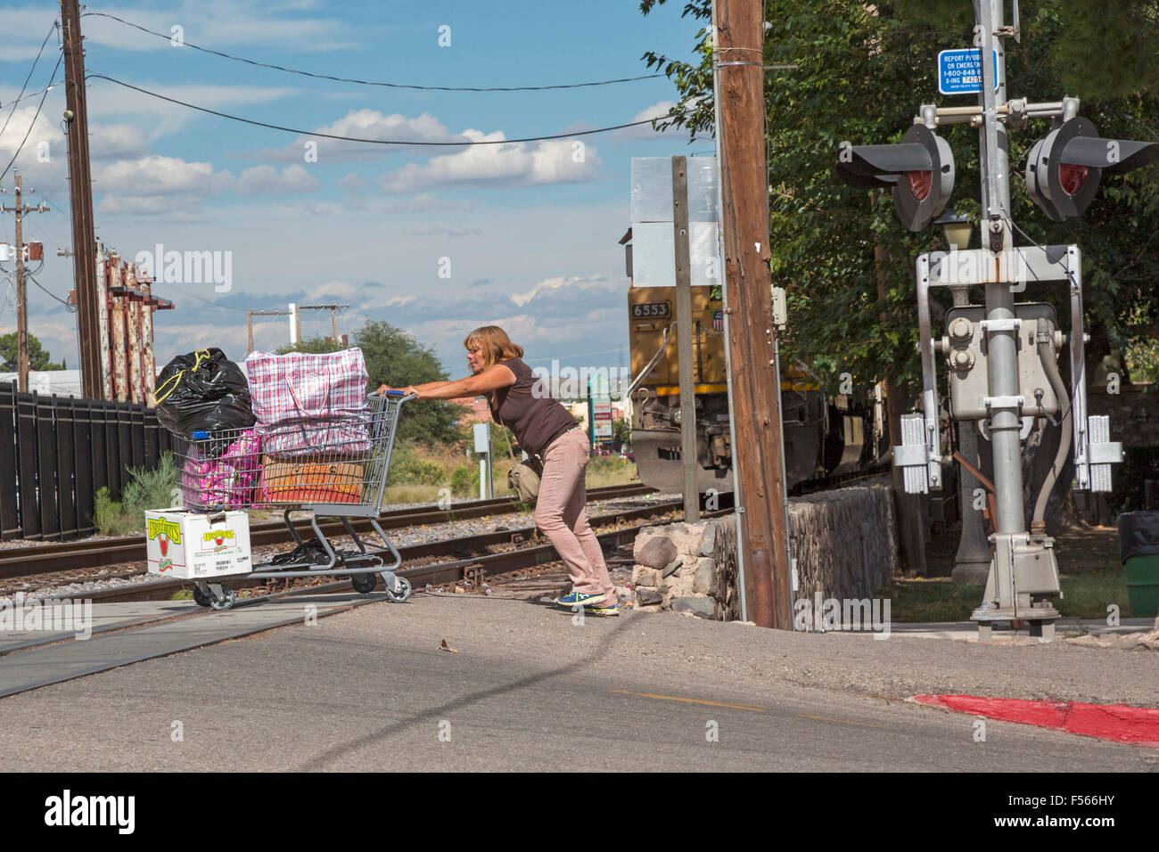 Nogales in Arizona - Una donna fa fatica a spingere un pesante carrello attraverso i binari della ferrovia Foto Stock