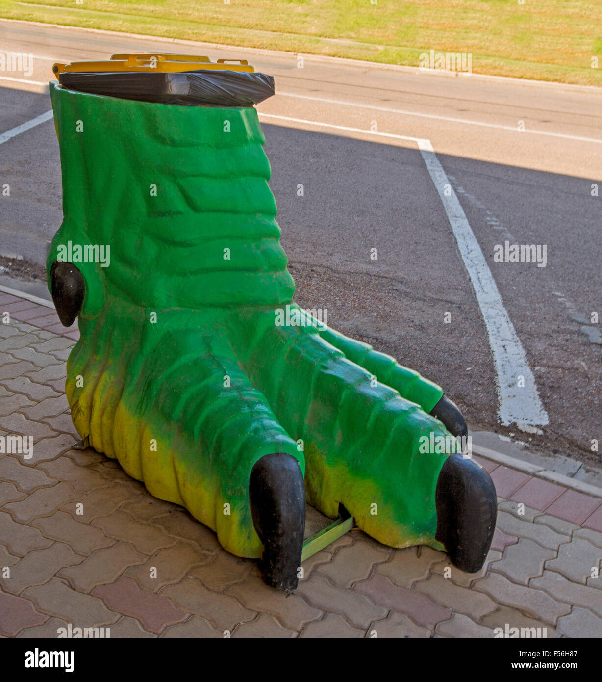 Unico / spazzatura spazzatura, replica del dinosauro verde piede sul sentiero pavimentato in Australian Outback città di Winton Foto Stock