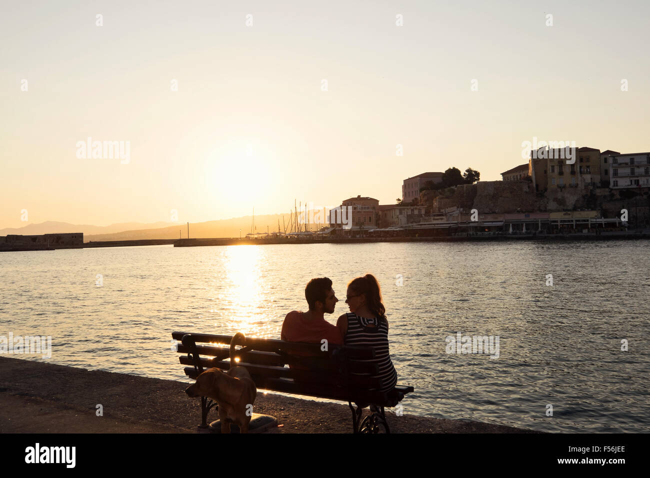 Una giovane coppia rilassatevi sulla foreshore del porto veneziano di Chania sull isola di Creta in Grecia Foto Stock
