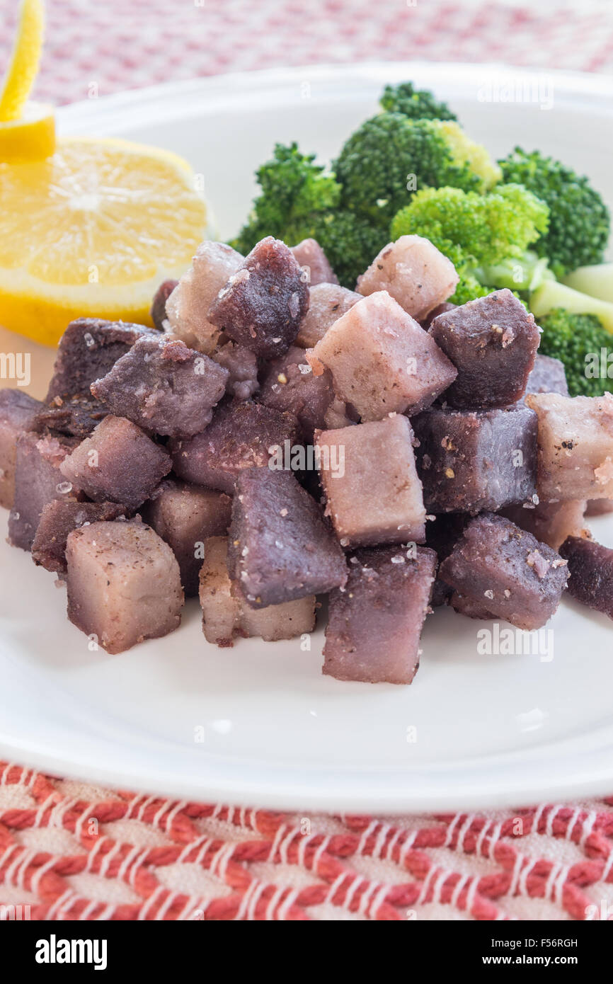 Taro a cubetti e homestyle fritte servite con broccoli Foto Stock