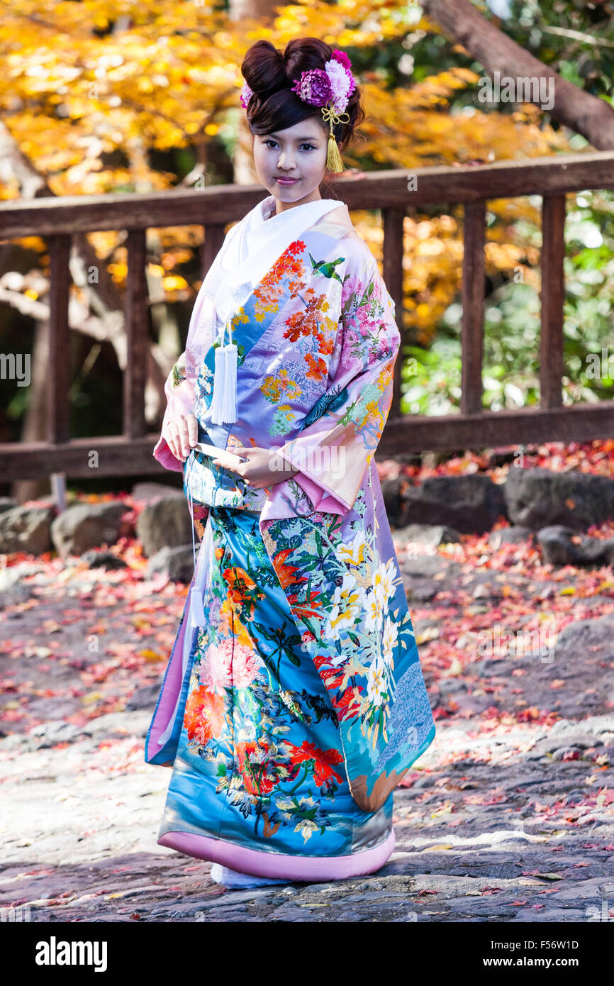 Il Giappone. Le donne giapponesi in kimono nuziale prosing esterno sul  lasciare il percorso coperto durante l'autunno. Vista laterale, girato  verso la faccia. Contatto visivo Foto stock - Alamy