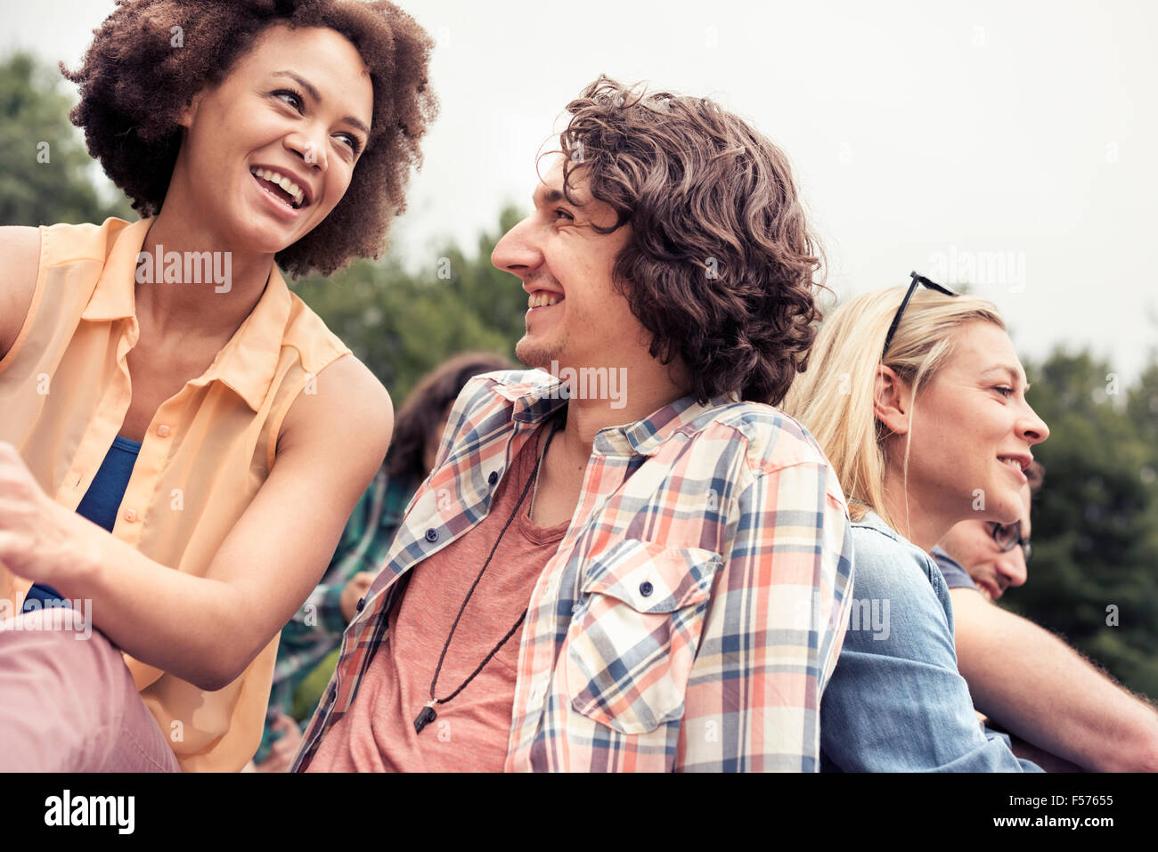 Una coppia giovane, un uomo e una donna tra gli altri all'aperto nella campagna. Foto Stock