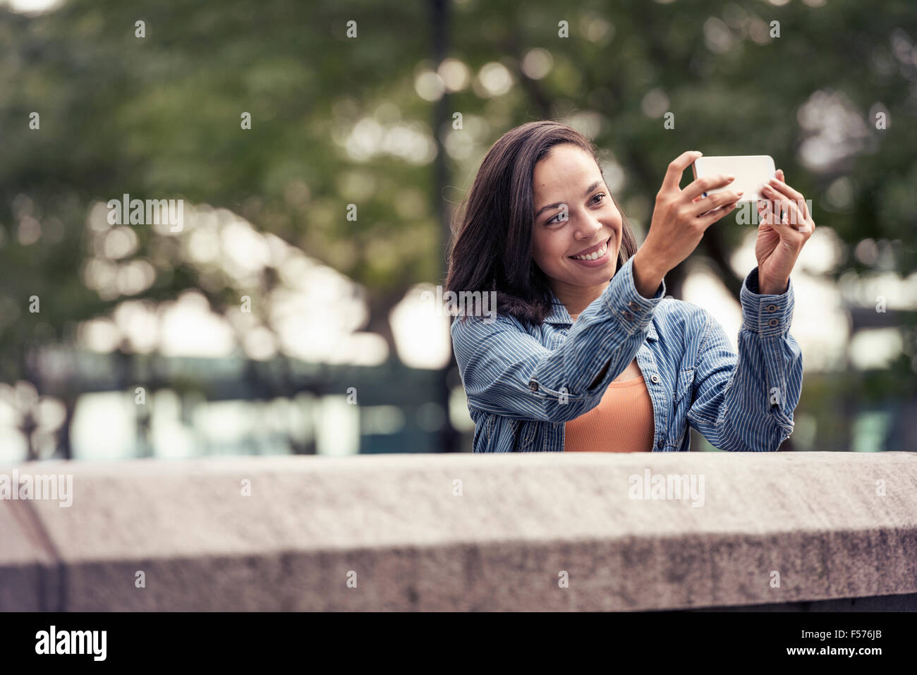 Una donna di scattare una fotografia o un selfie con uno smart phone Foto Stock