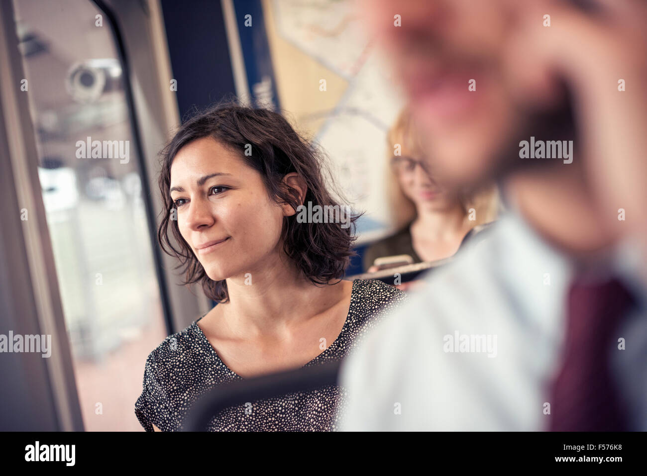 Una donna su un autobus affollato guardando fuori della finestra Foto Stock
