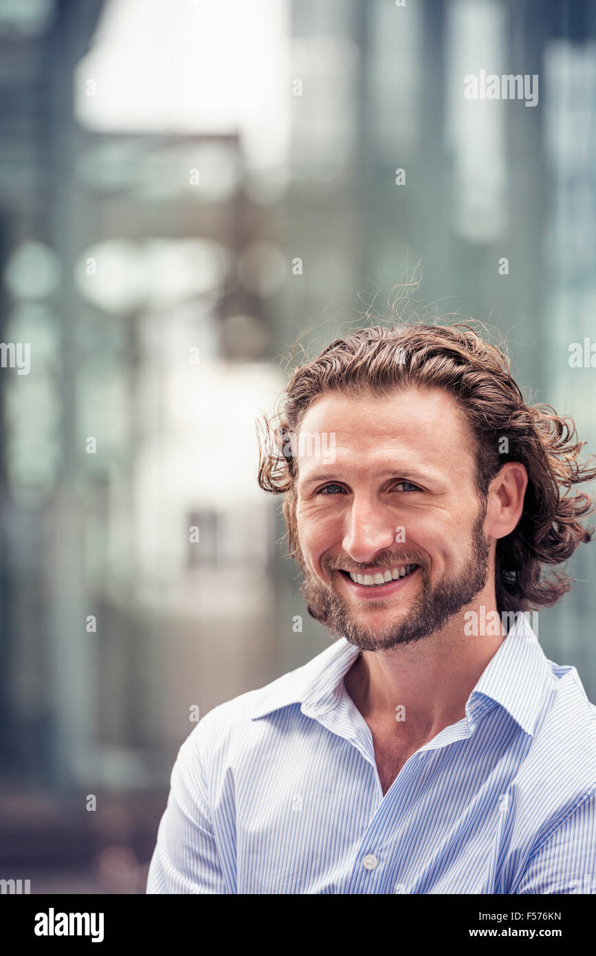 Un uomo con i capelli ricci e una barba di una strada della citta'. Foto Stock