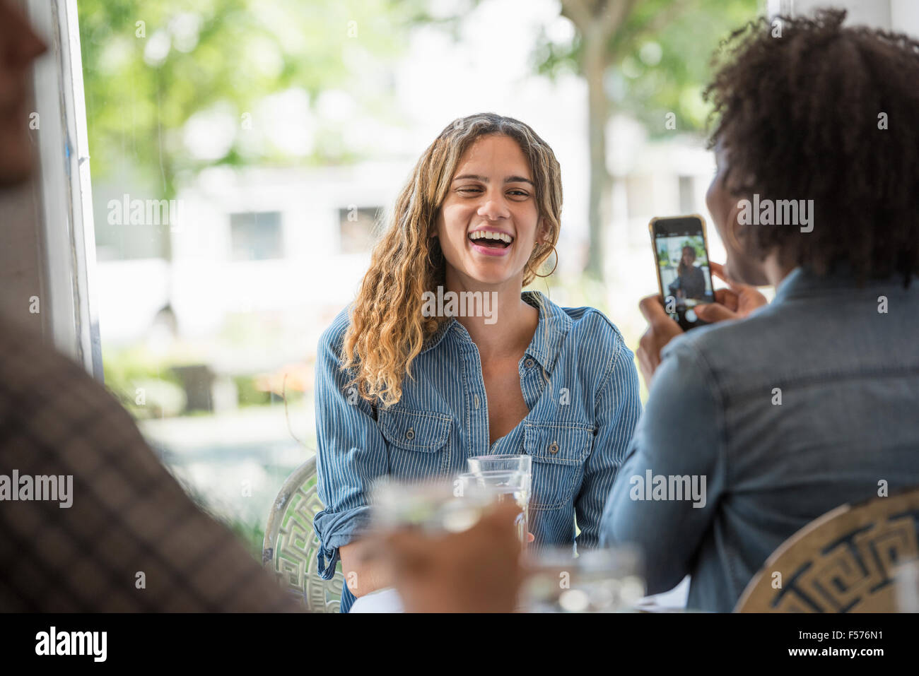 Una donna che parla di una fotografia di un amico utilizzando un telefono intelligente. Foto Stock