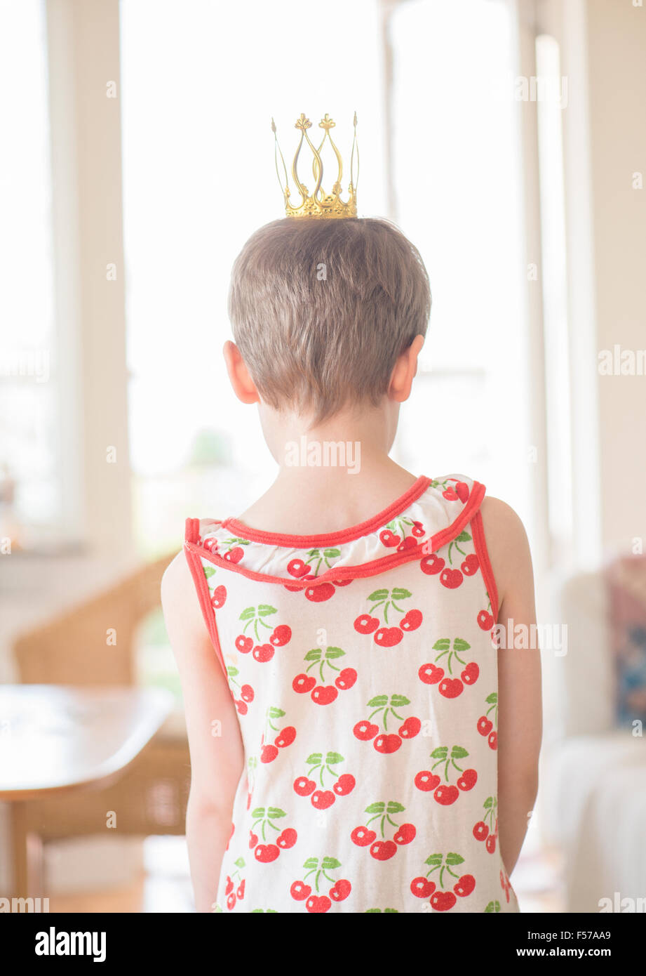 Bambina gioca la principessa di casa in soggiorno. Concetto di infanzia, di aspirazioni e di innocenza. Foto Stock