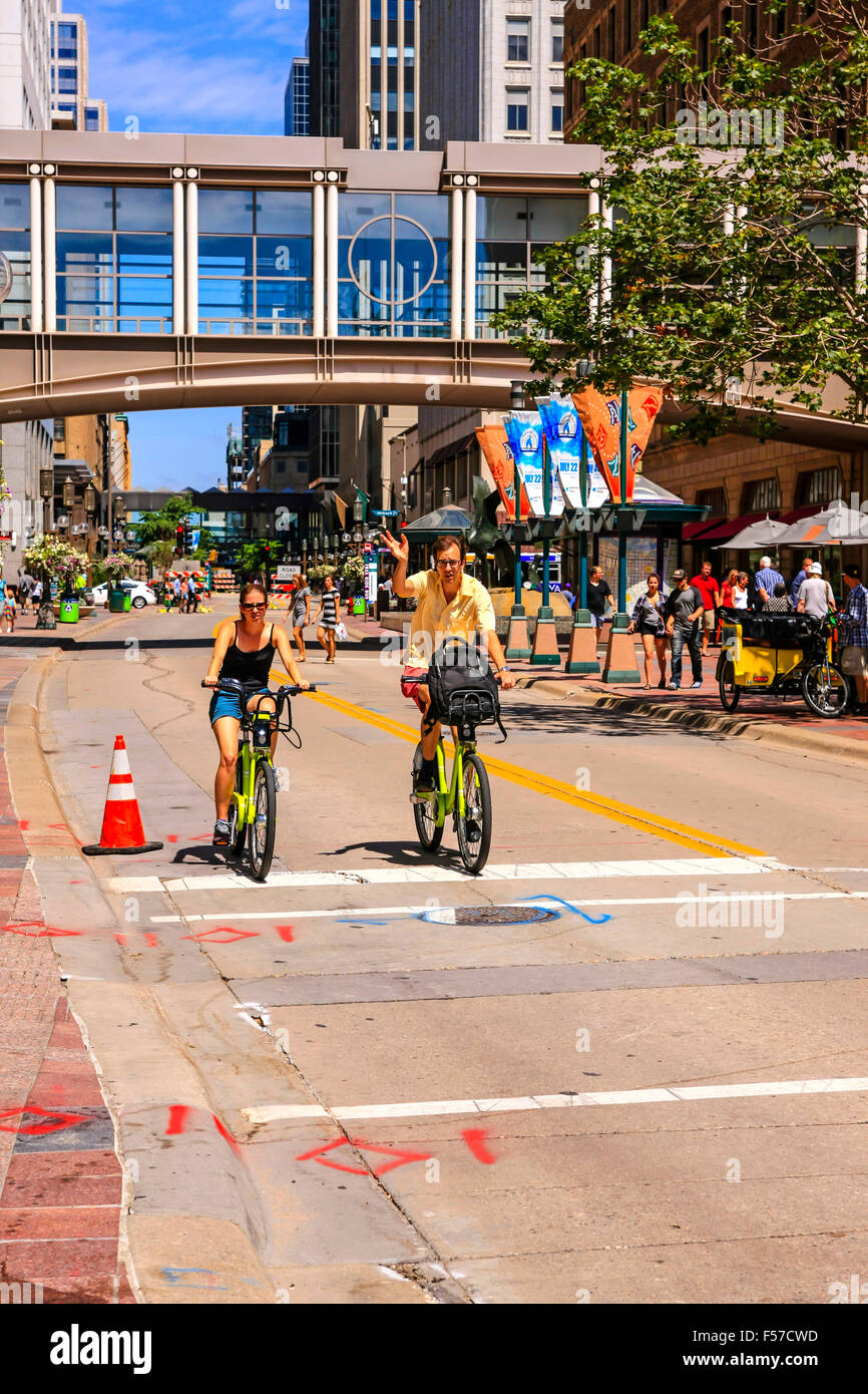 Due persone in bicicletta lungo Nicolette Mall in Downtown Minneapolis MN Foto Stock