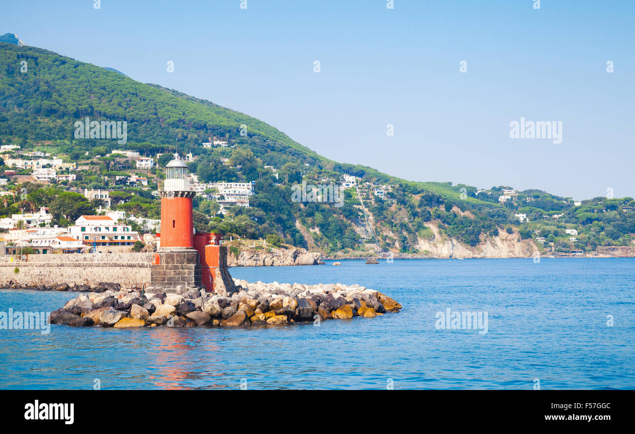 Rosso Torre Faro sulla scogliera di pietra. Ingresso a Ischia Porto. Mare Mediterraneo, Italia Foto Stock