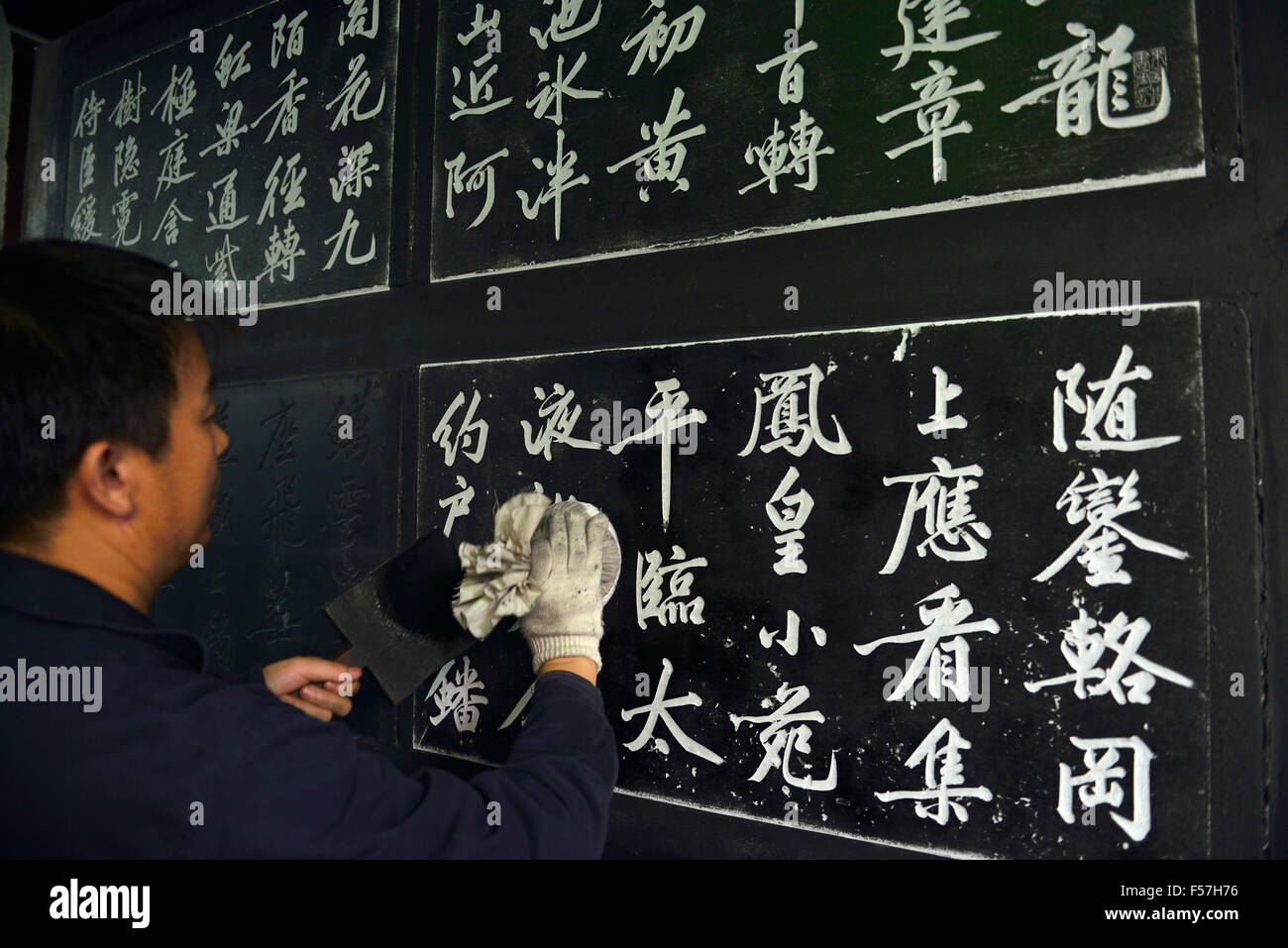 Un dipendente che effettua sfregamenti dal lavoro di calligrafia di Huang Tingjian presso la foresta di Stele di Xian, Cina. Foto Stock