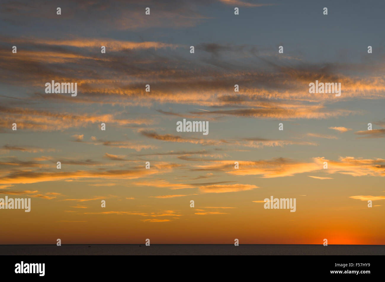 Cielo di tramonto sul mare, con underlit nuvole blu e arancione la gradazione di colore. Foto Stock