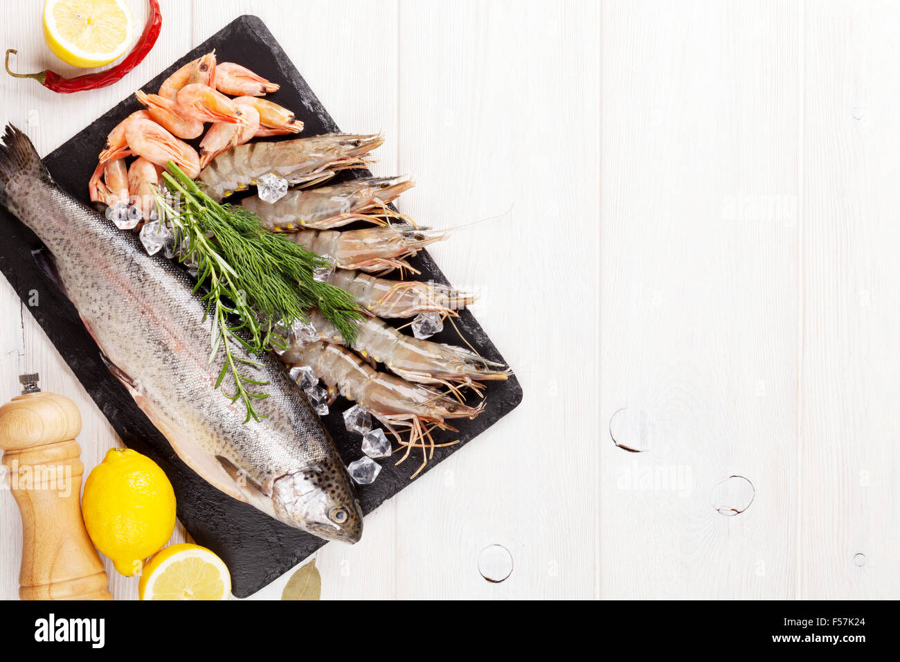 Crudo fresco il cibo del mare con spezie sulla lastra di pietra su un tavolo di legno dello sfondo. Vista da sopra con lo spazio di copia Foto Stock