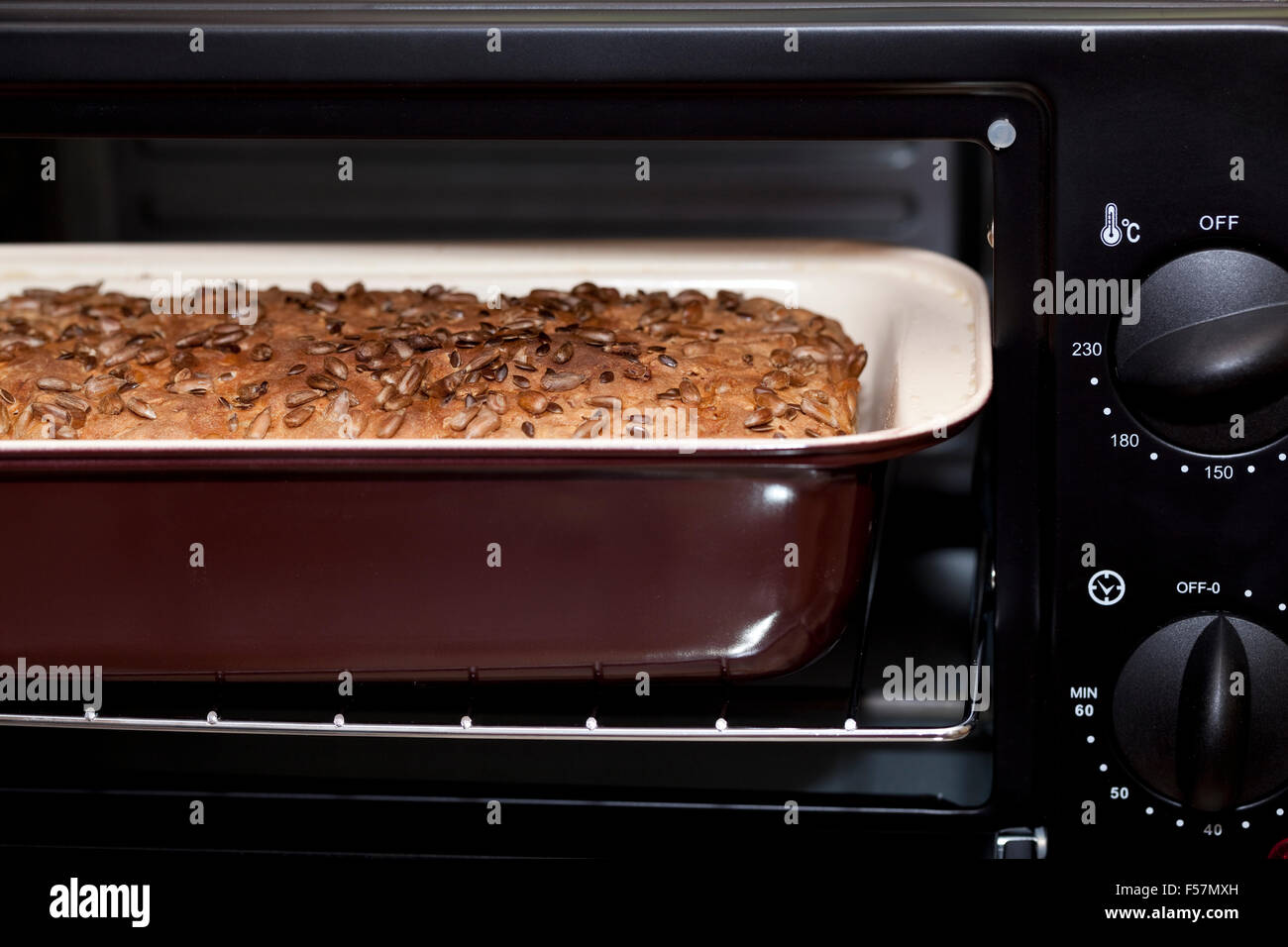 Piccolo cotto il pane con semi di girasole in forno Foto Stock