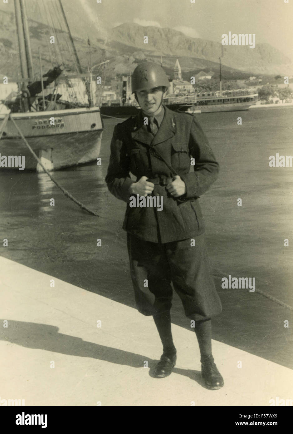 Un soldato italiano con il casco su un dock Foto Stock