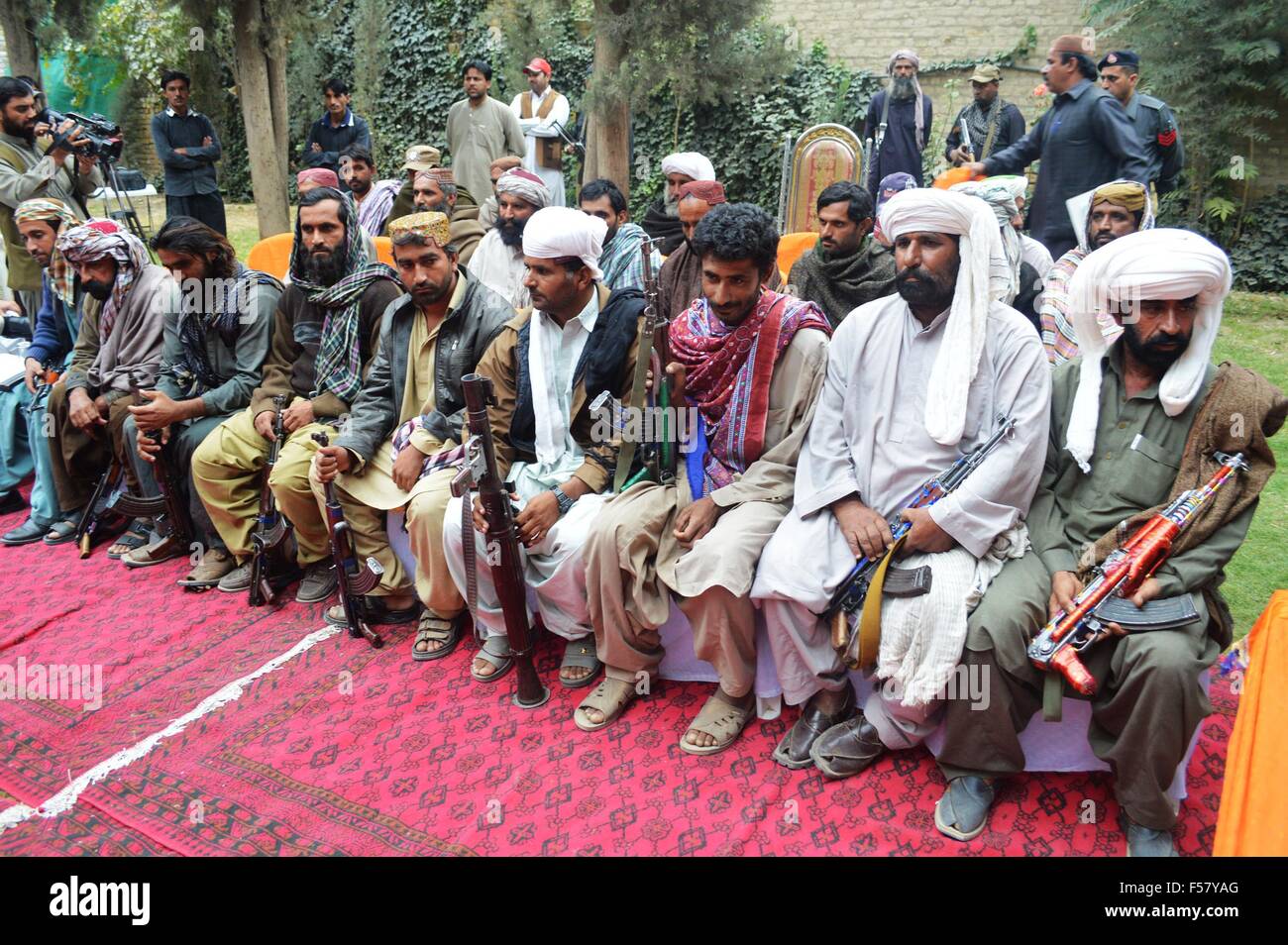 Quetta, Pakistan. 29 ott 2015. I militanti si siedono prima di consegnare le loro armi durante una cerimonia di consegna a Quetta, in Pakistan, Ottobre 29, 2015. Un totale di 23 militanti appartenenti alla tribù Marri hanno ceduto alle autorità con le armi a Quetta. © Irfan/Xinhua/Alamy Live News Foto Stock