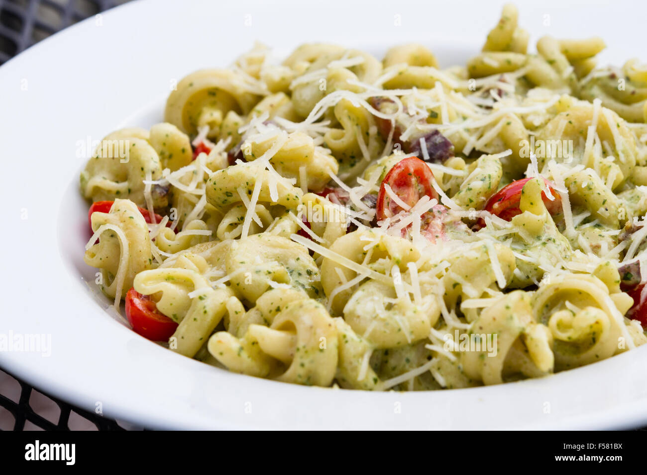 Primo Piano Di Un Piatto Di Cibo Costituito Da Trotolle La Pasta Con Un Pesto Leggero Di Basilico E Fette Di Pomodori Ciliegini Foto Stock Alamy