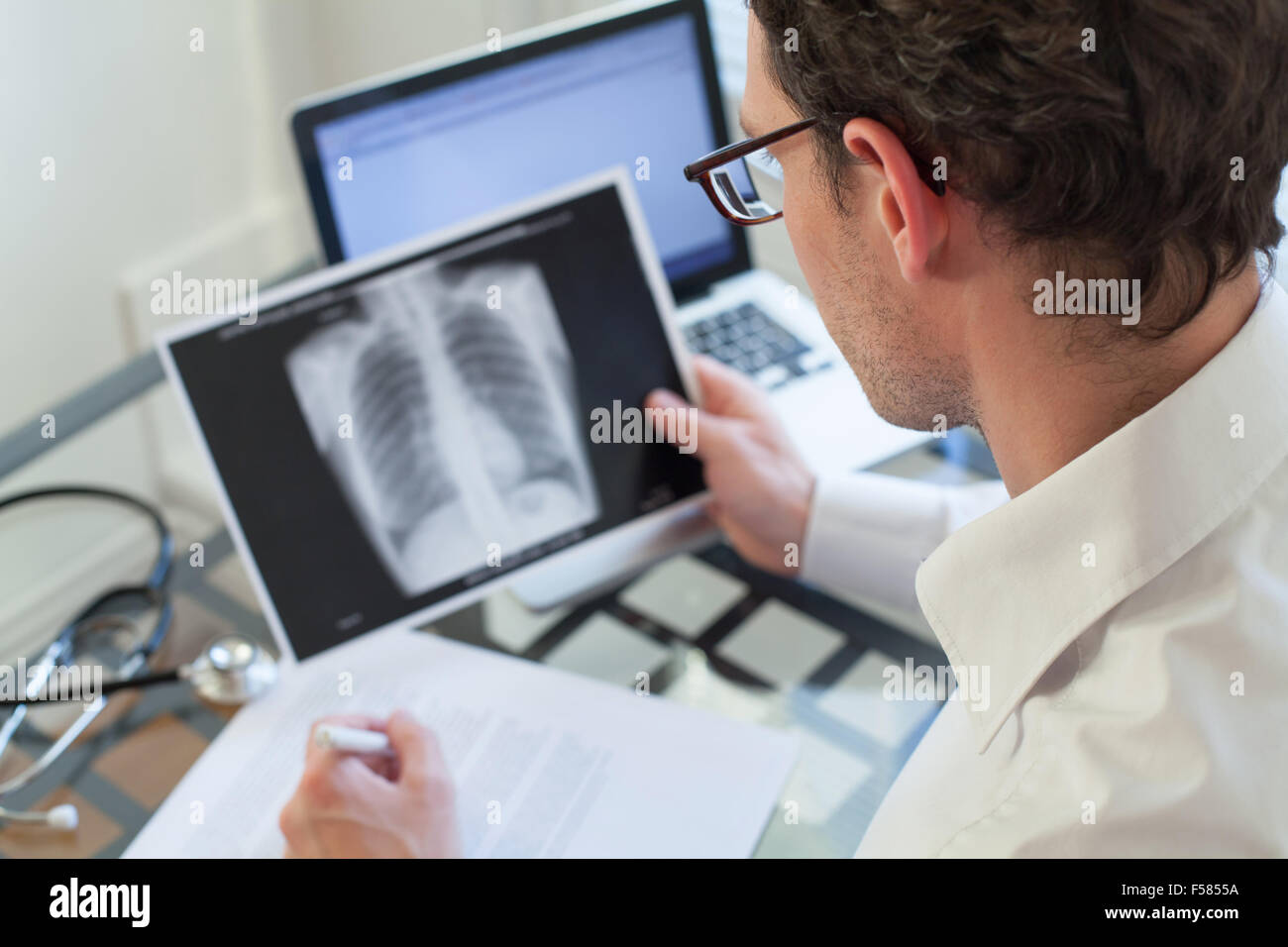 Medico cerchi a raggi x dei polmoni e diagnosi di scrittura Foto Stock