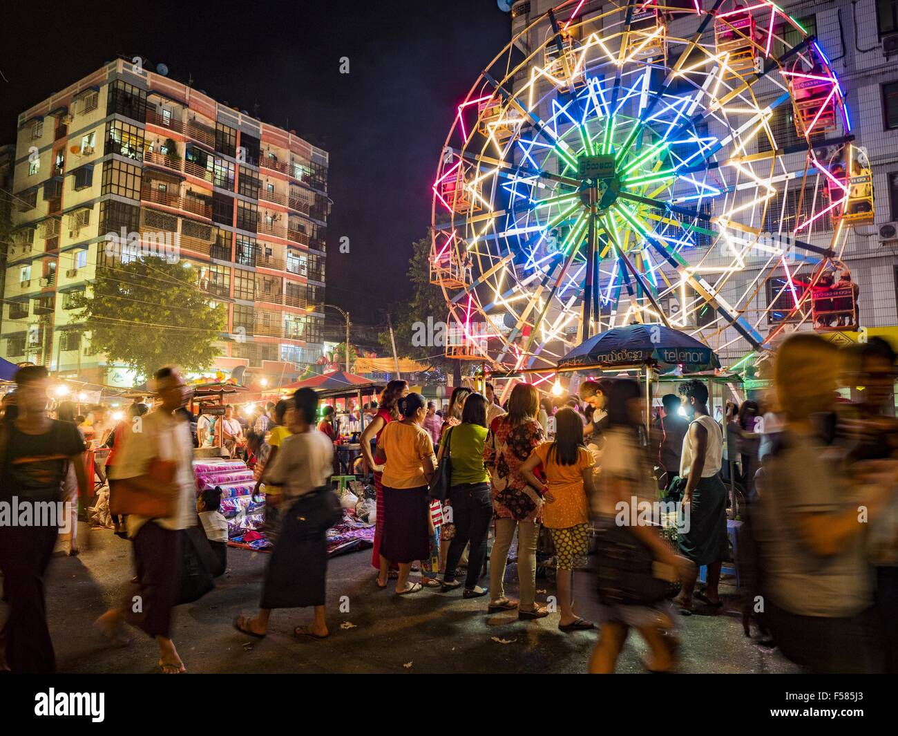 Yangon, Divisione di Yangon, Myanmar. 29 ott 2015. Un human powered ruota panoramica Ferris in una strada di carnevale nel centro di Yangon. L'elettricità è scarso in Myanmar, soprattutto nelle aree rurali e la maggior parte dei carnevali di viaggio uso human powered corse. Lavoratori salire in cima alla ruota panoramica Ferris e poi tirarlo intorno ad arrivare è la filatura. Essi fare lo stesso con il Merry Go Round, ma invece di salire alla cima essi tirarlo intorno a. Credito: ZUMA Press, Inc./Alamy Live News Foto Stock