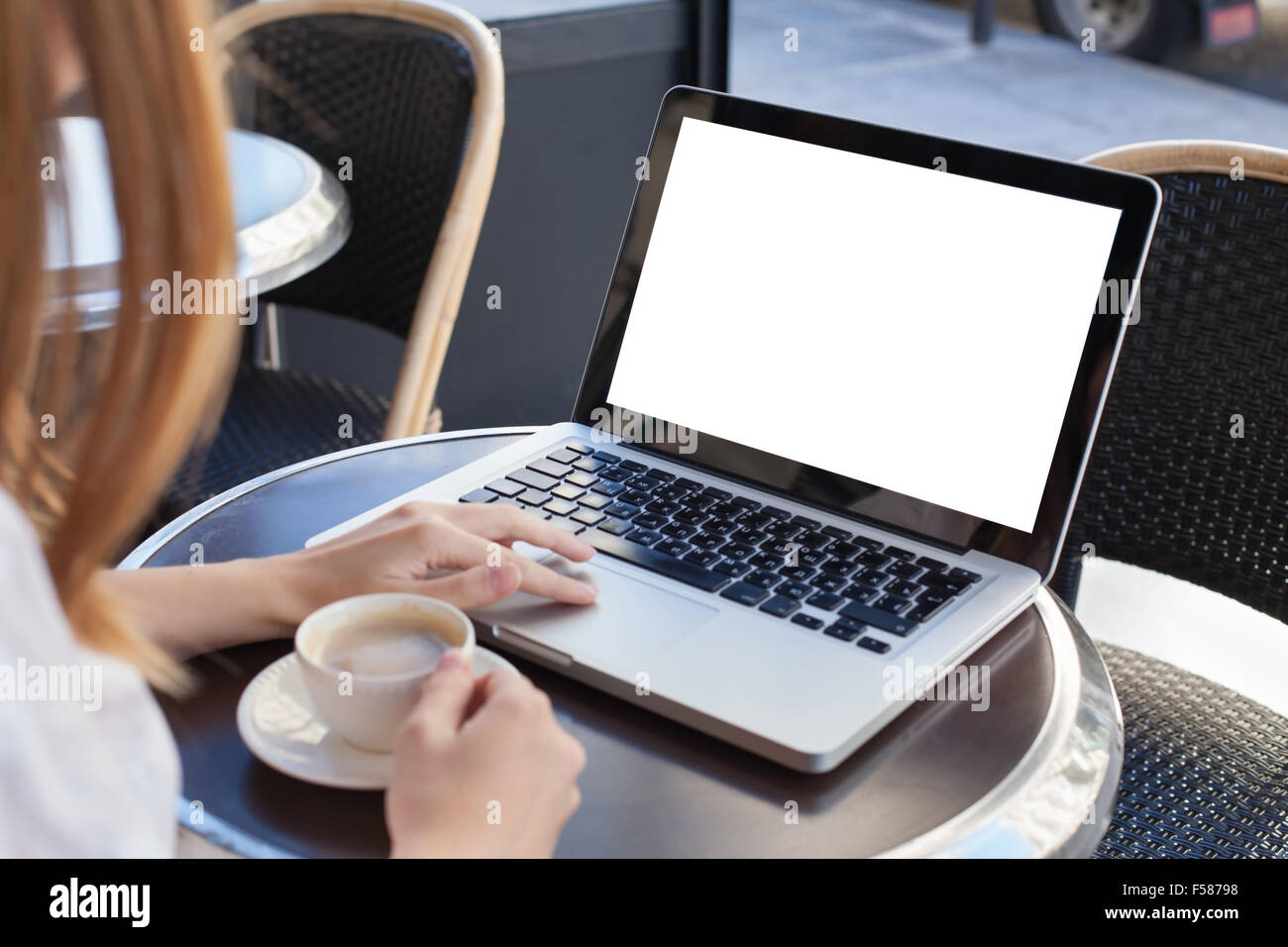 Donna con notebook con schermo vuoto in cafe Foto Stock