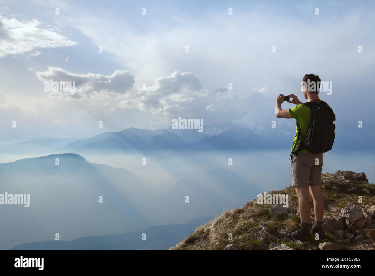 Escursionista tenendo la foto del bellissimo paesaggio di montagna con il telefono cellulare Foto Stock