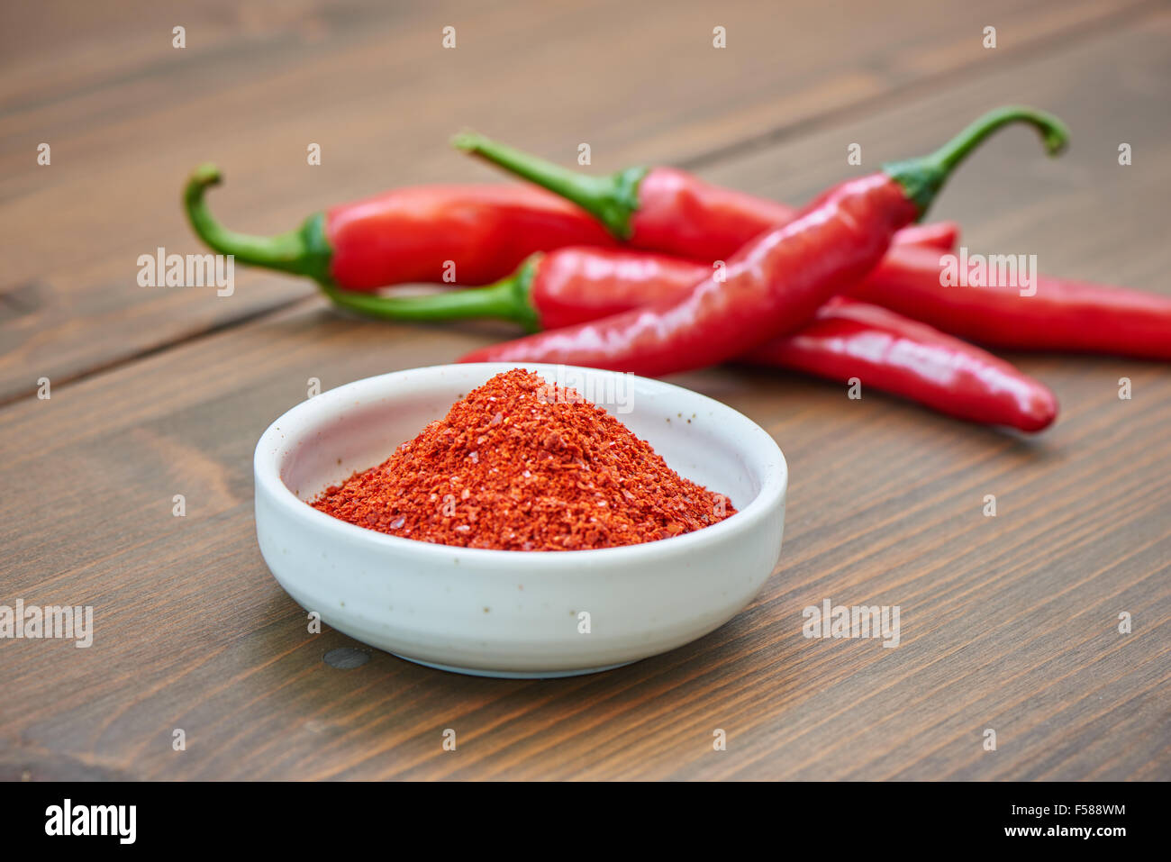 Primo piano della Korean peperoncino in polvere con il peperoncino su una tavola di legno Foto Stock