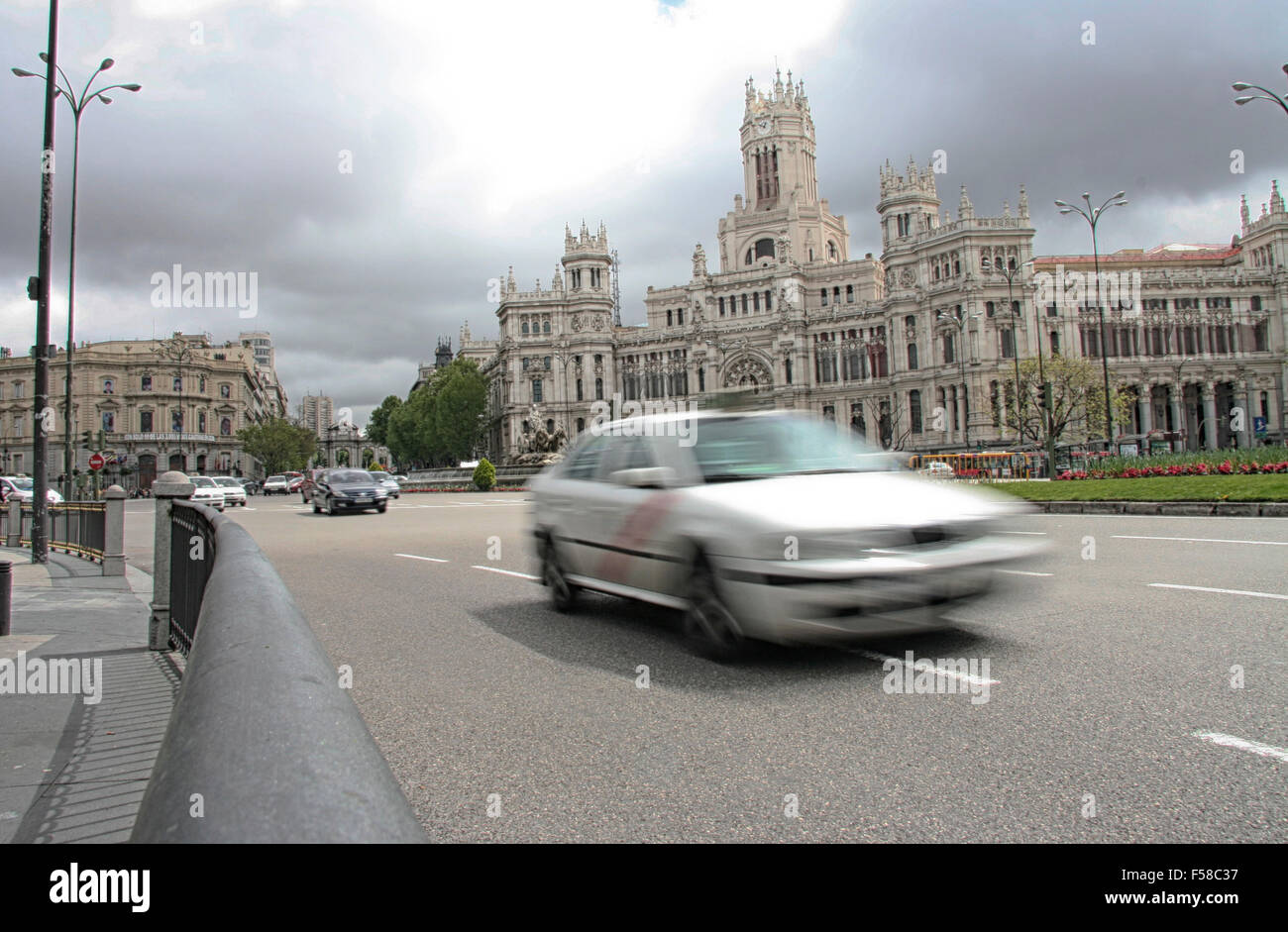 Taxi attraversando la Plaza de Cibeles a Madrid, Spagna. Una lunga esposizione, sfocatura del movimento Foto Stock