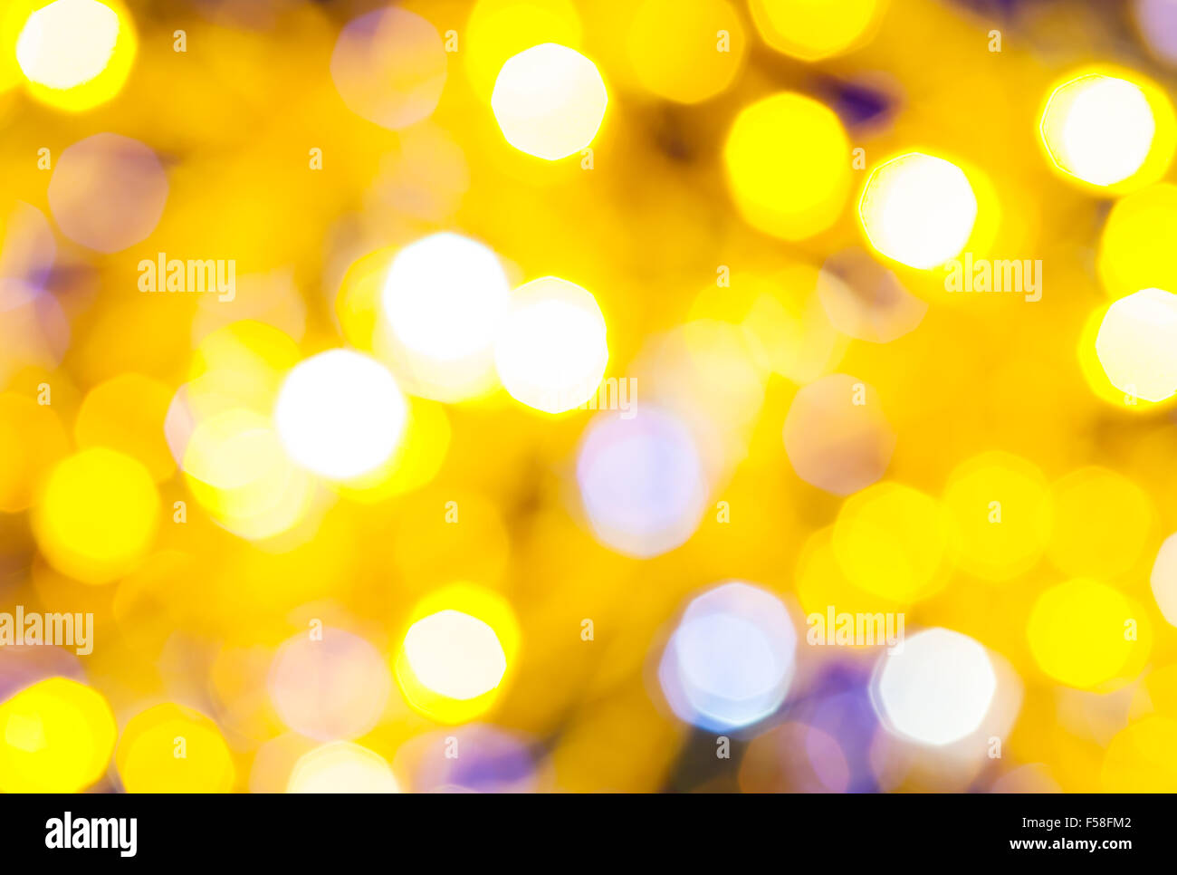 Abstract sfondo sfocato - luce gialla e viola lo sfarfallio delle luci di Natale bokeh di le ghirlande elettriche su albero di Natale Foto Stock
