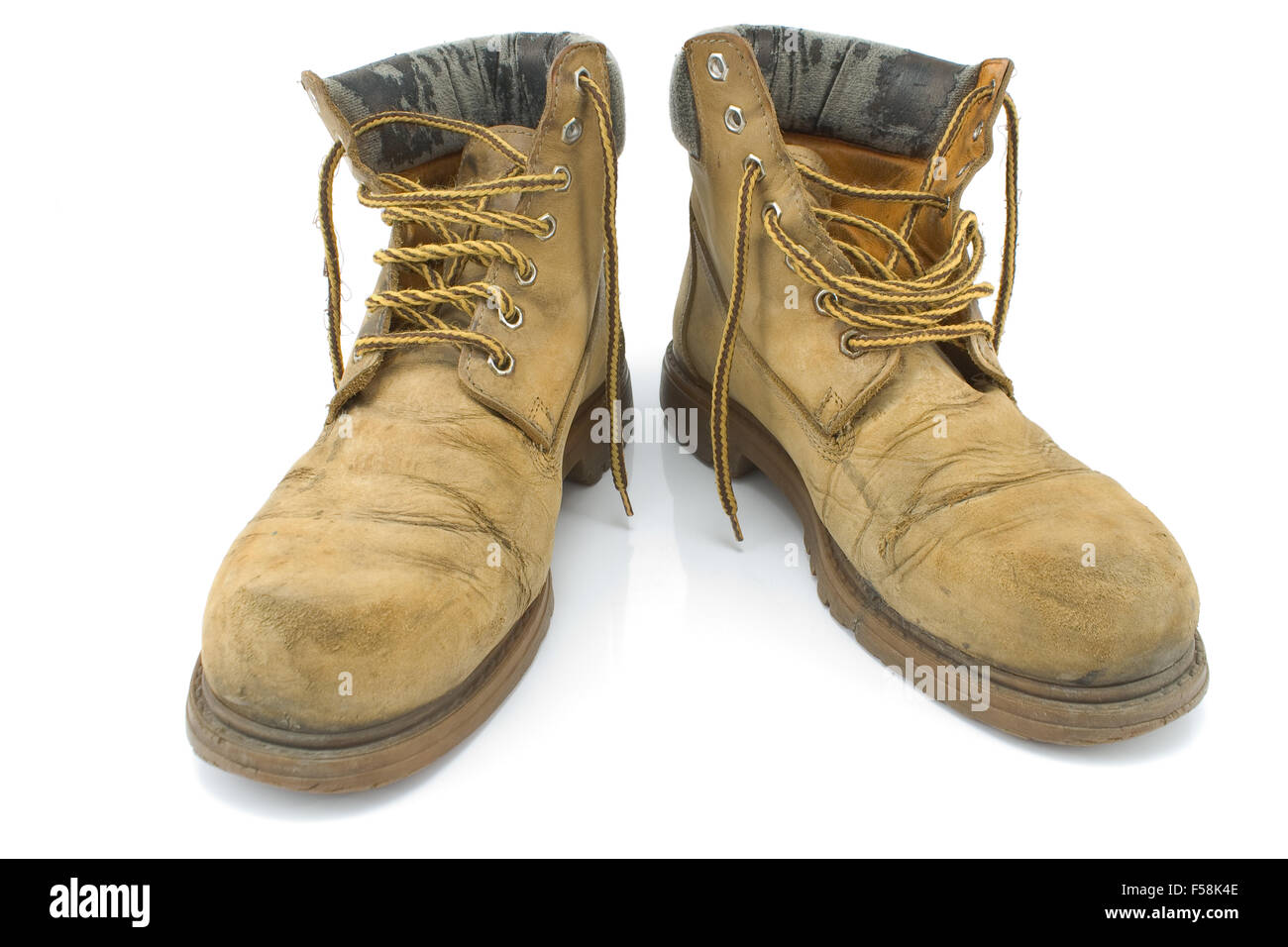 Old Dirty giallo stivali da lavoro isolato su bianco Foto Stock