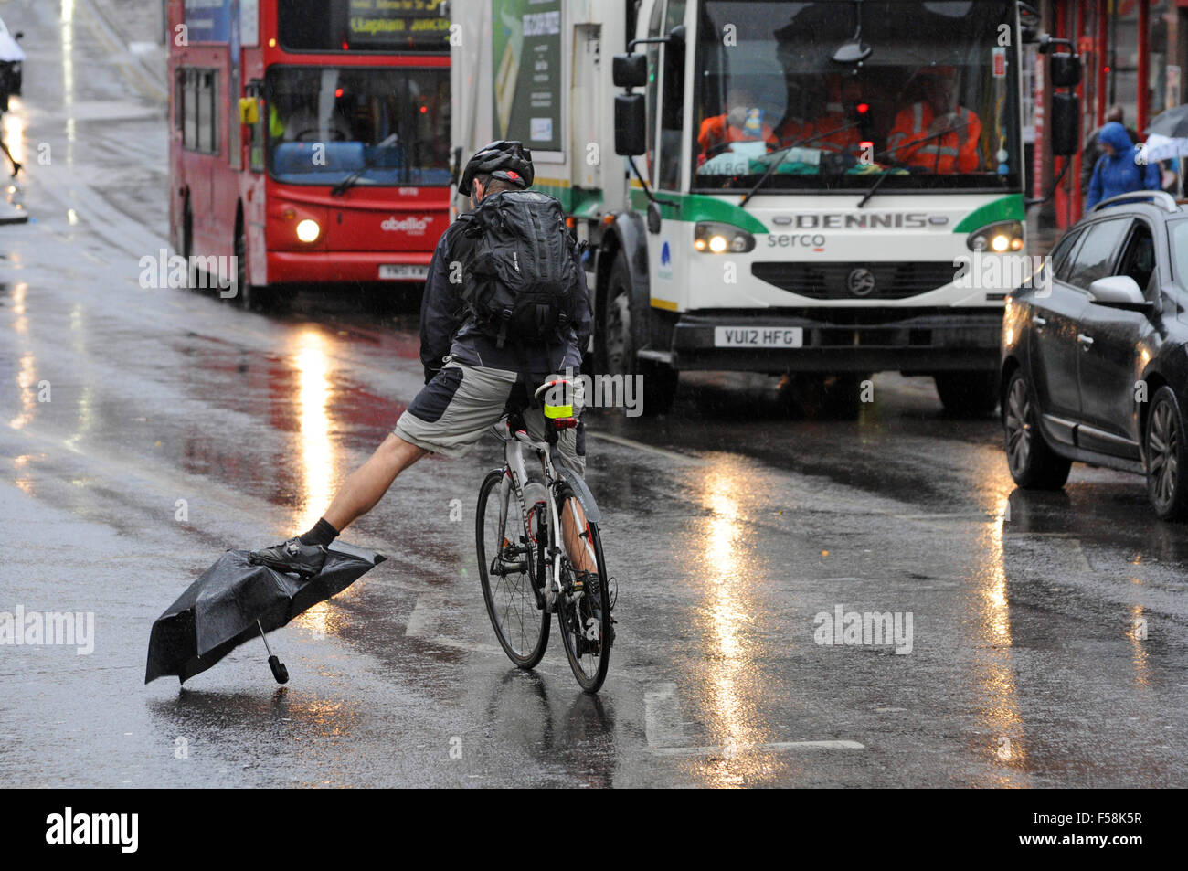 Londra, UK, 30 ottobre 2015, ciclista evita perso ombrello in strada a piovoso venerdì mattina a Clapham Junction come pendolari in testa al lavoro. Credito: JOHNNY ARMSTEAD/Alamy Live News Foto Stock