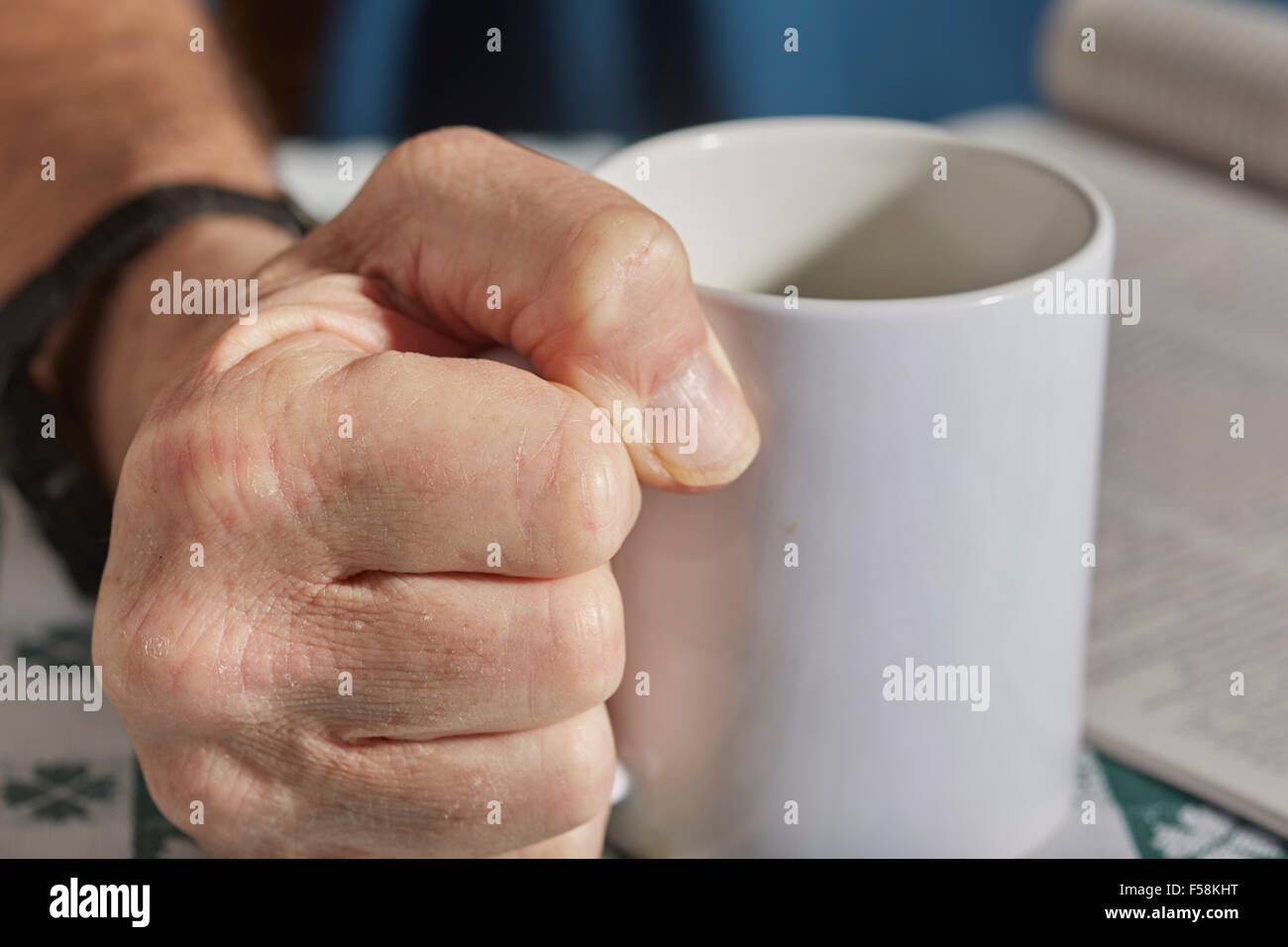 L'uomo leggendo una rivista e di presa di una tazza di caffè Foto Stock