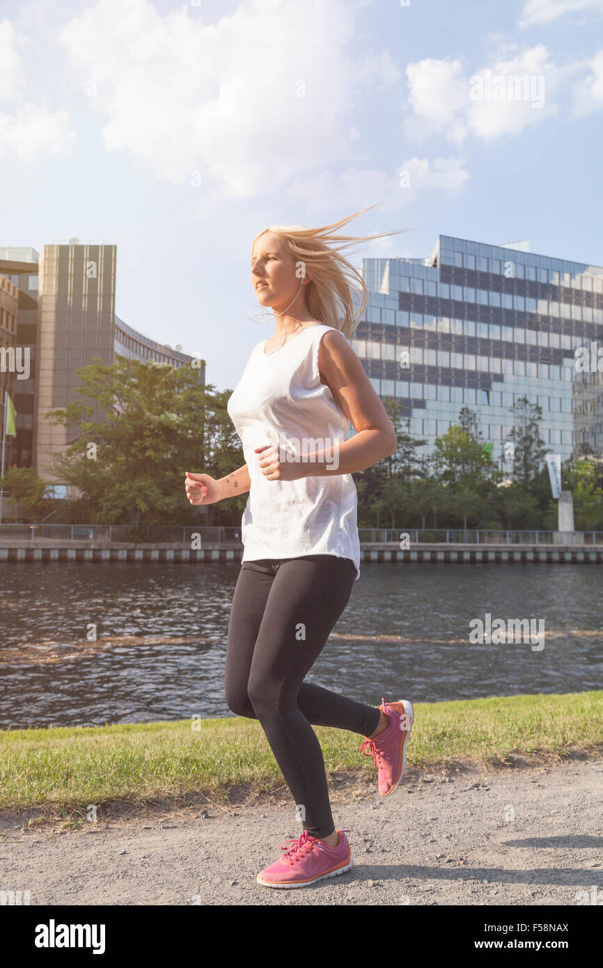 Giovane donna jogging in città Foto Stock