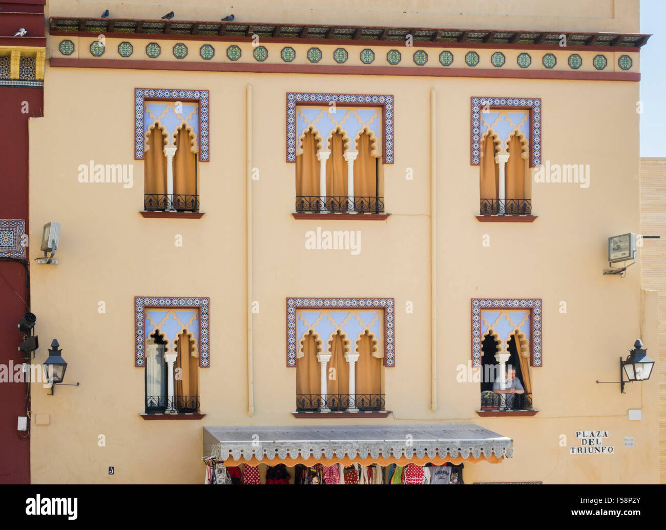 Esterno della casa decorata in stile moresco con l uomo del peering da finestra a passanti a Cordoba, Spagna Foto Stock