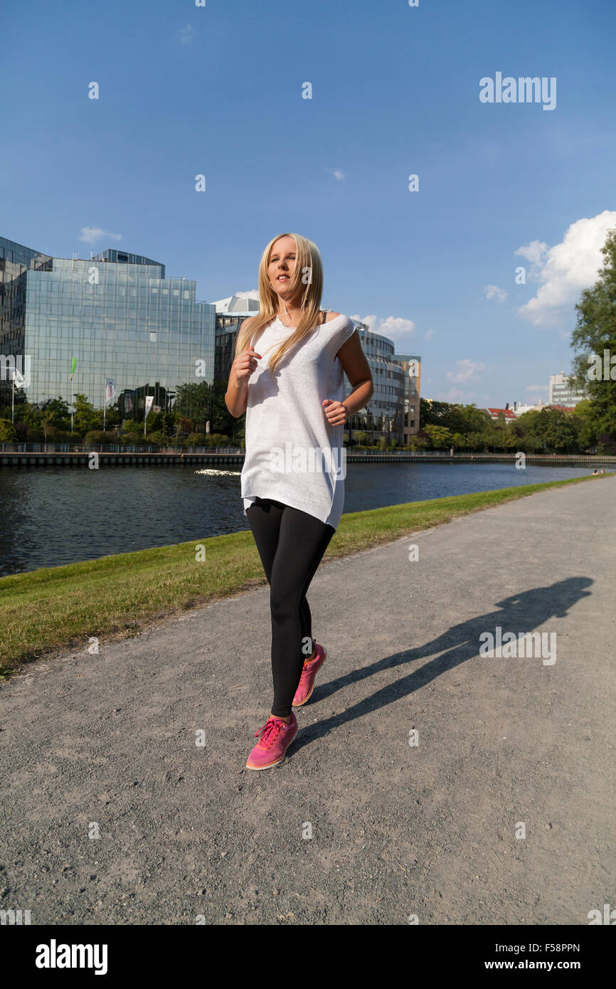 Donna jogging nei pressi di un fiume a Berlino Foto Stock