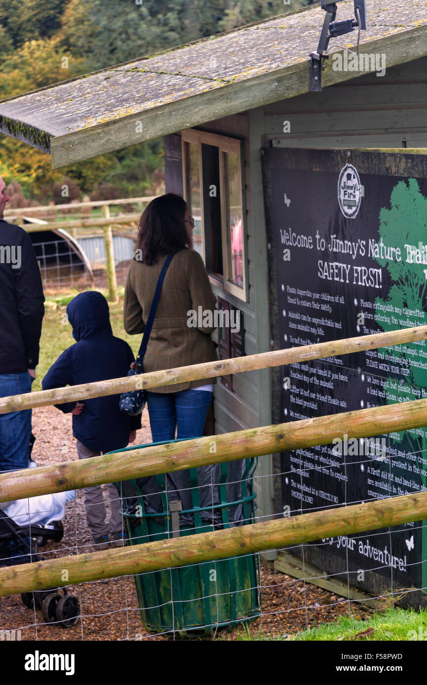 Donna di pagare al chiosco per ingresso al sentiero natura, Jimmy's Farm, Wherstead, Ipswich, Regno Unito Foto Stock