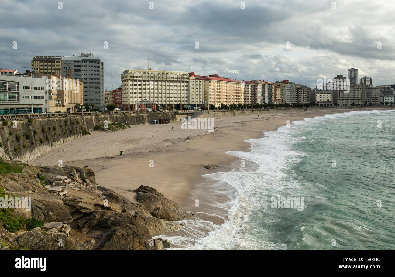 Il litorale di sabbia, il mare, le onde e la Esplanade di fronte degli edifici moderni A Coruña, Galizia, Spagna Foto Stock