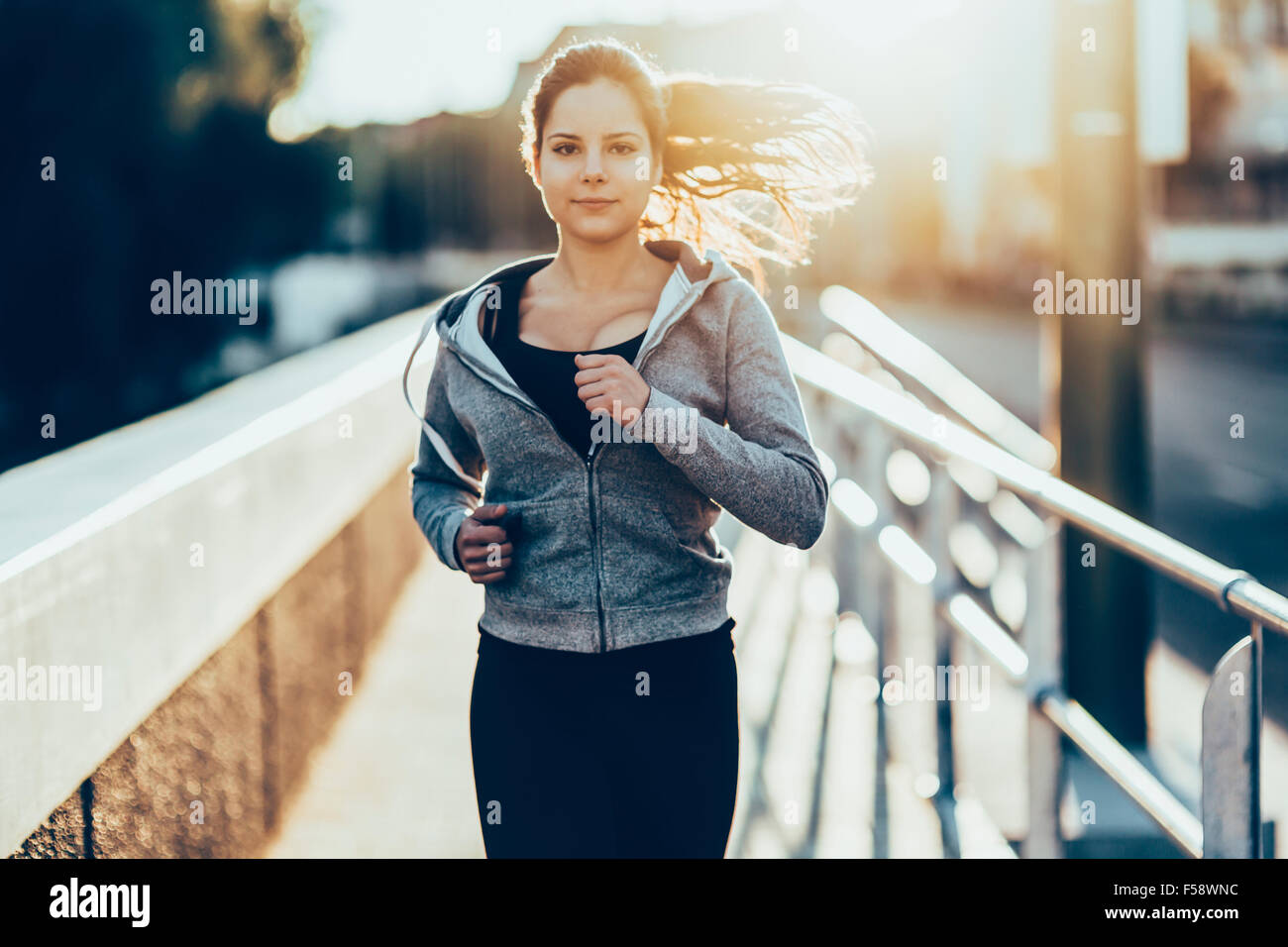 Donna sportiva jogging in città per mantenere il suo corpo e la sua anima in forma Foto Stock