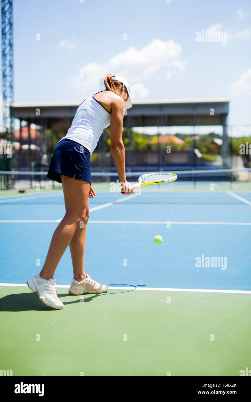 Bellissima femmina giocatore di tennis che serve per esterno Foto Stock
