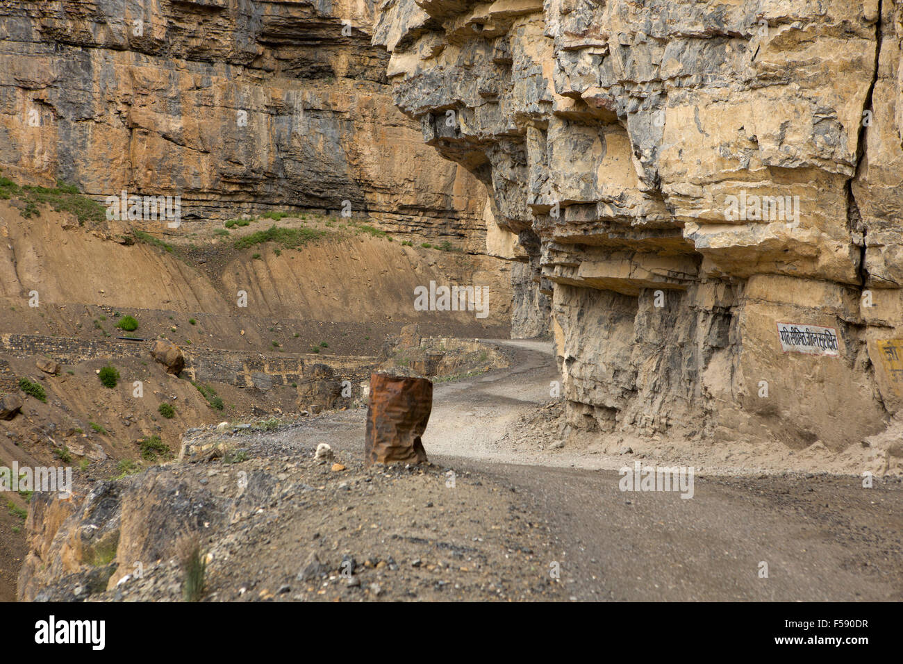 India, Himachal Pradesh, Spiti Valley, Losar, pericolose montagna stretta strada tagliata nella roccia a strapiombo, canna barriera di sicurezza Foto Stock