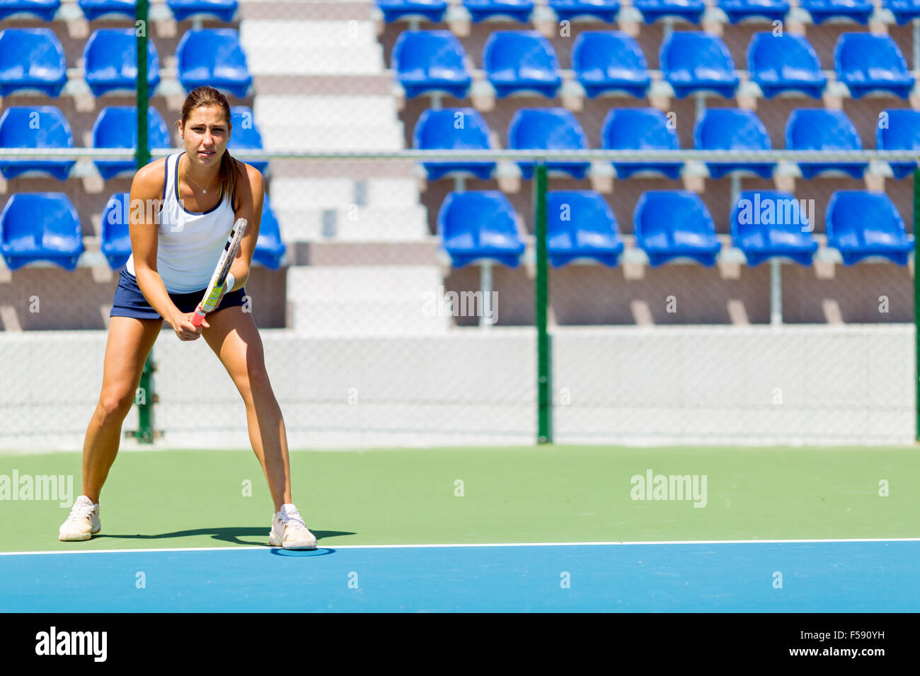 Femmina giocatore di tennis in ricezione di un atteggiamento di servizio Foto Stock
