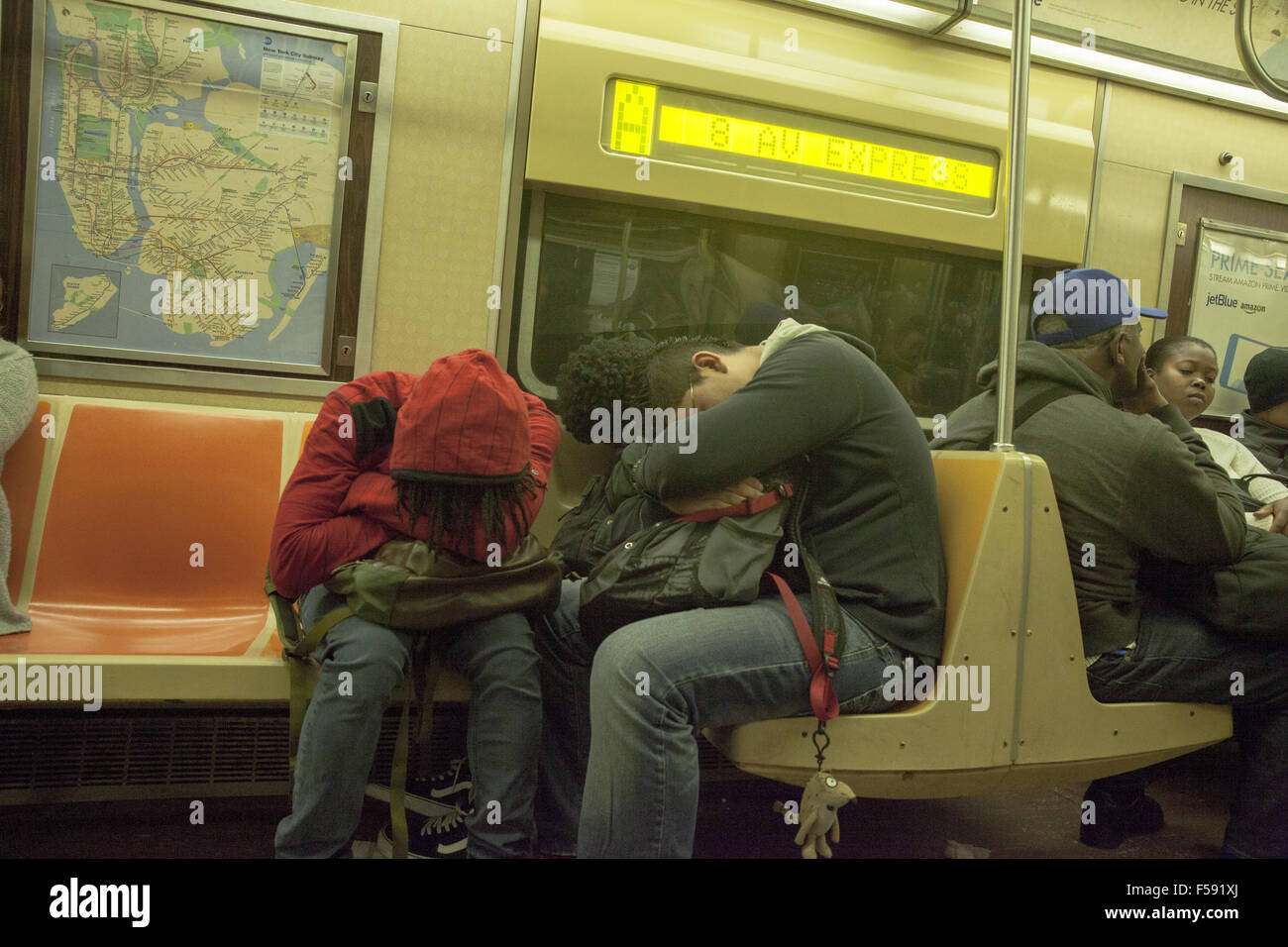 Assonnato ragazzi sui loro mattina il tragitto in metropolitana per high school di Brooklyn, New York. Foto Stock