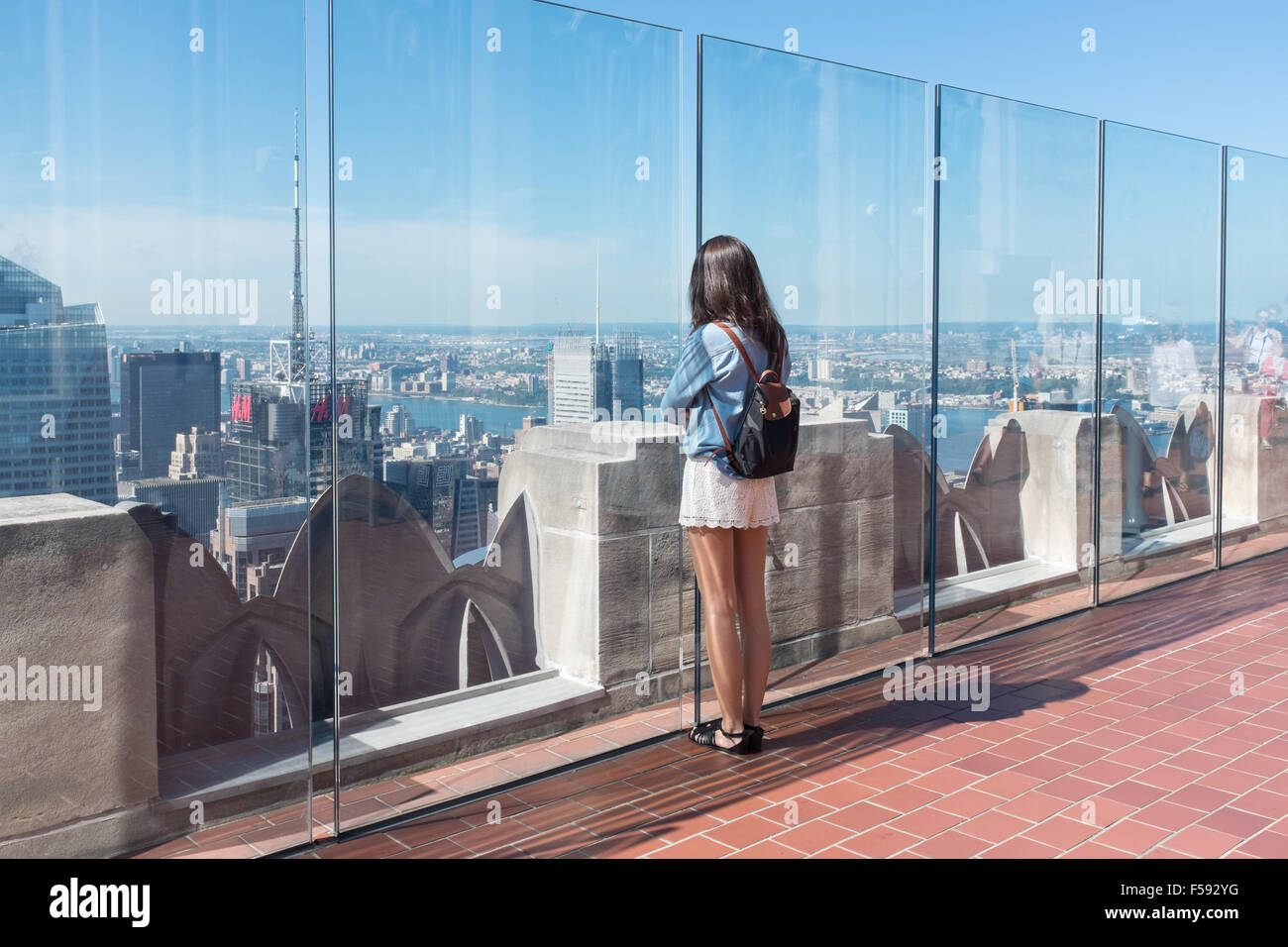Turista femminile ammirando la vista su Manhattan dal ponte di osservazione del Rockefeller Center di New York Foto Stock