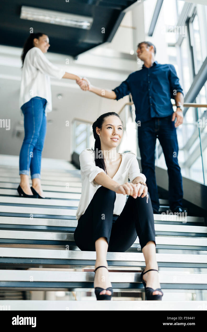 Un gruppo di uomini di affari che stringono le mani sulle scale in un bellissimo ufficio moderno Foto Stock