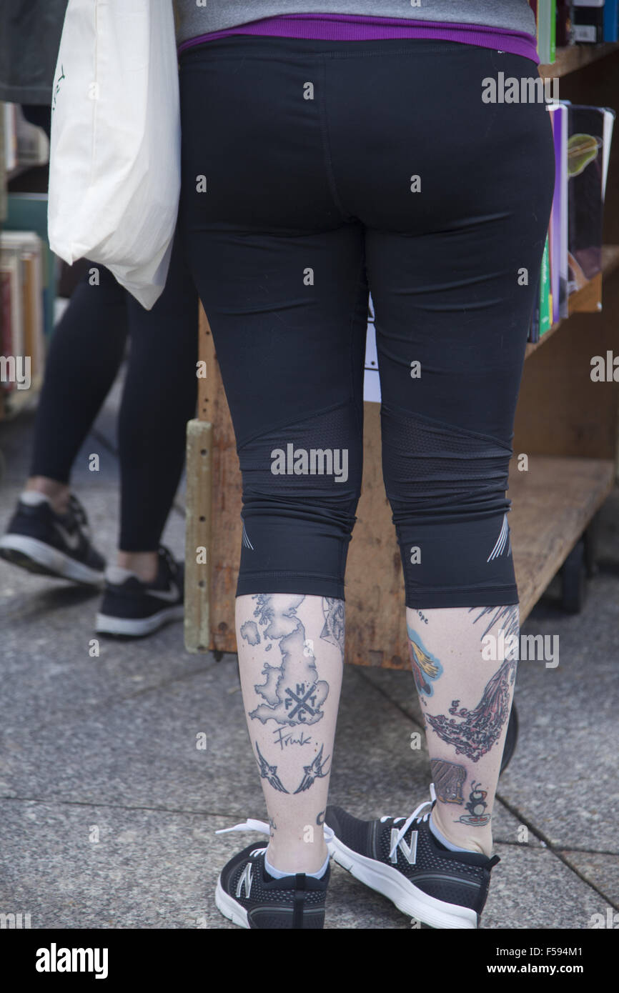Una donna tatuata gambe ad una vendita di libri al Brooklyn Public Library, NYC. Foto Stock