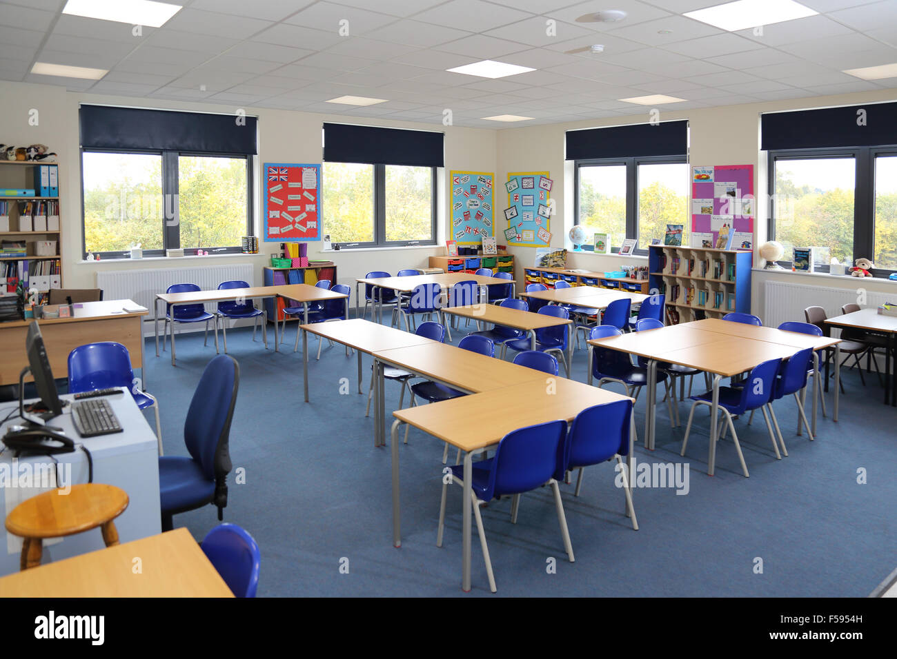 Una classe in una nuova costruzione UK junior school. Mostra scrivania, sedie e insegnanti computer stazione di lavoro. Foto Stock