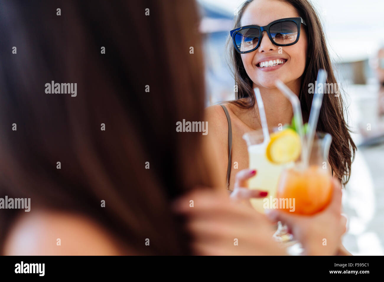 Femmina allegro gli amici a bere un cocktail in estate e sorridente Foto Stock