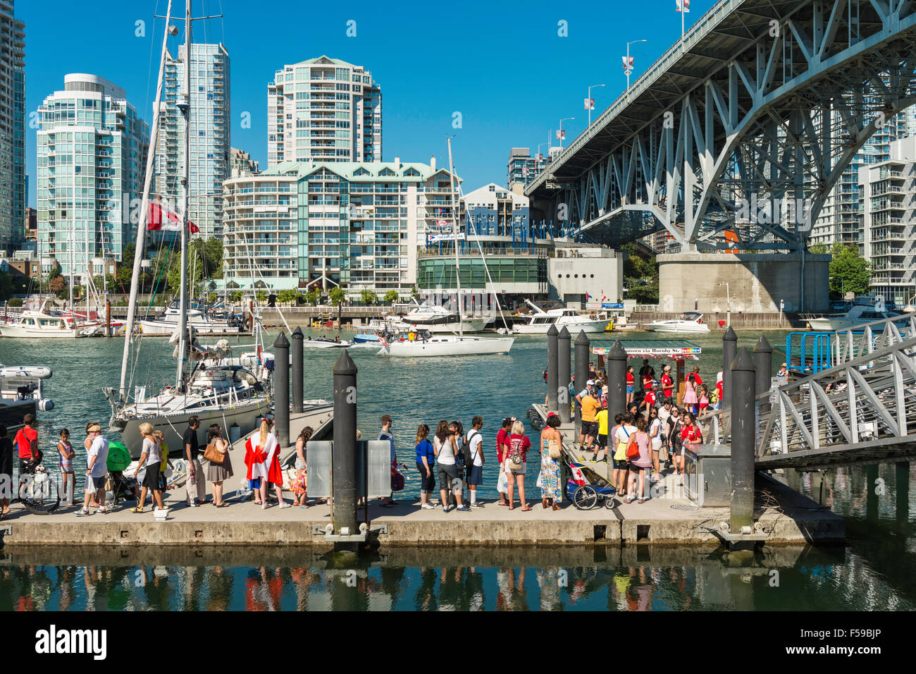 I passeggeri in attesa di aquabus False Creek traghetti a Granville Island dock sul Canada Il giorno 1 luglio 2015. Foto Stock