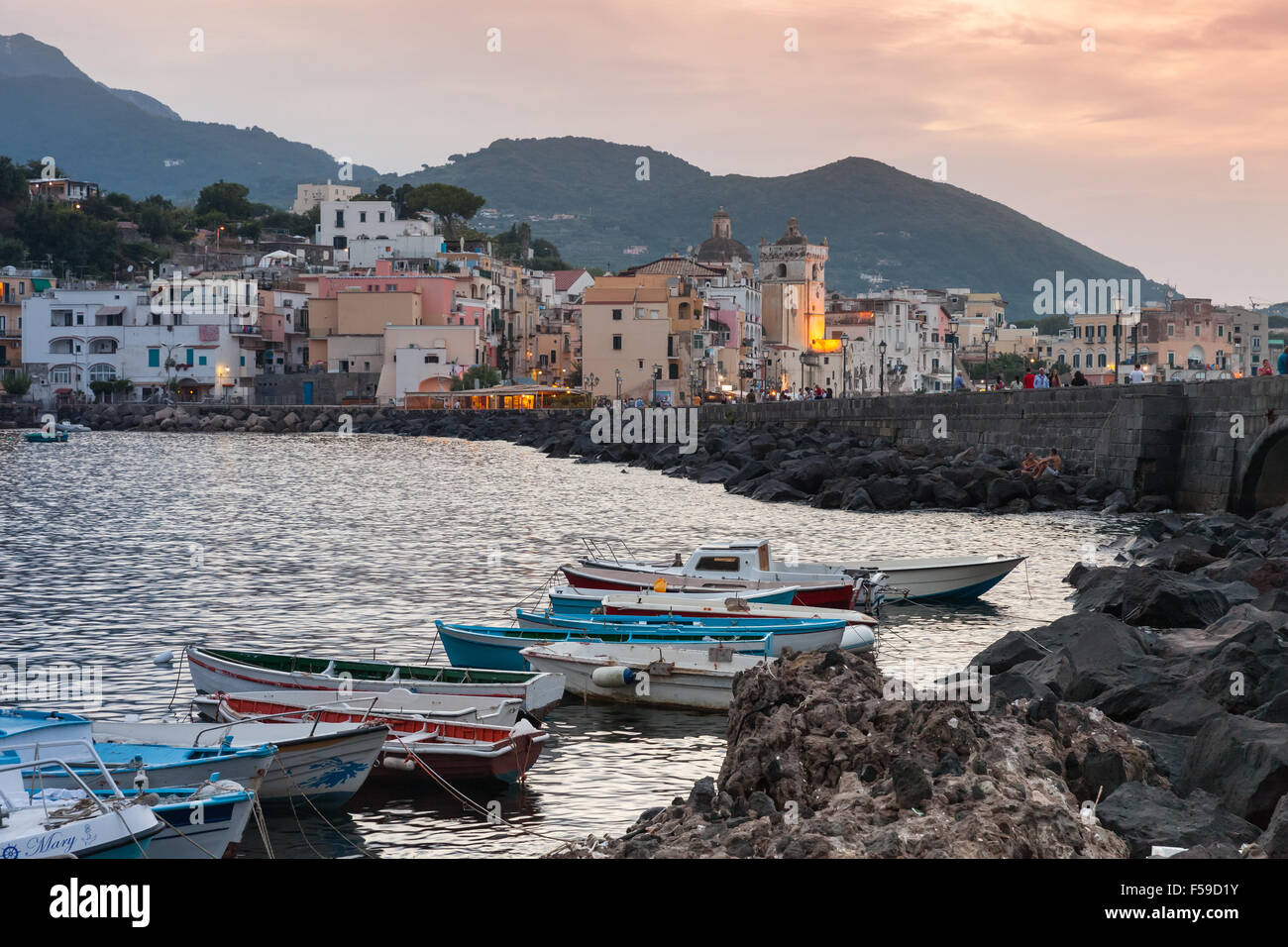 Ischia, Italia - 15 agosto 2015: Cityscape con barche di Ischia Porto al tramonto mediterraneo sulla costa del mare Foto Stock